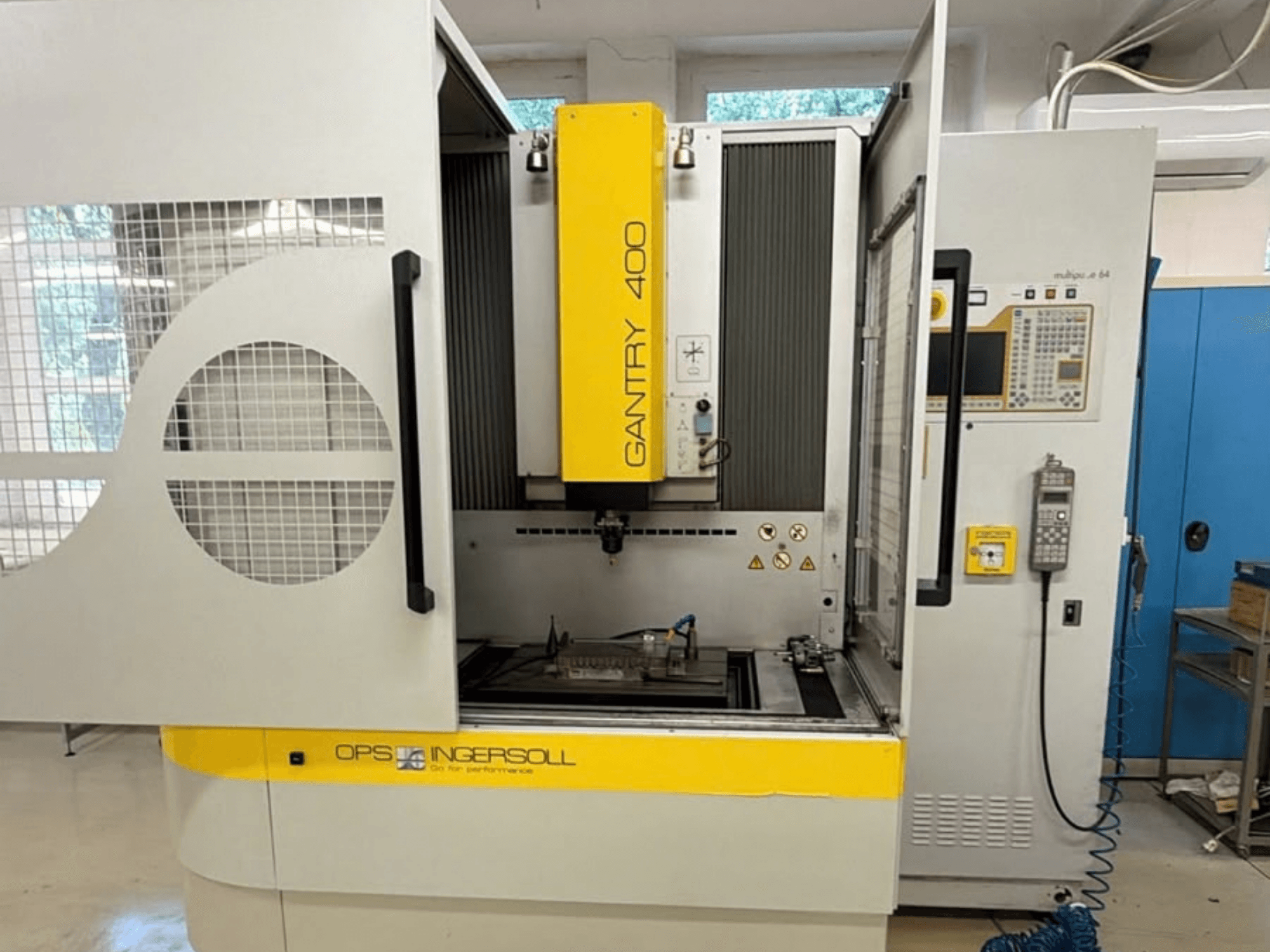 Vista frontal de la máquina de electroerosión por penetración INGERSOLL Gantry 400, en la que se aprecian las puertas abiertas y el panel de control, con la pieza de trabajo colocada en el interior.