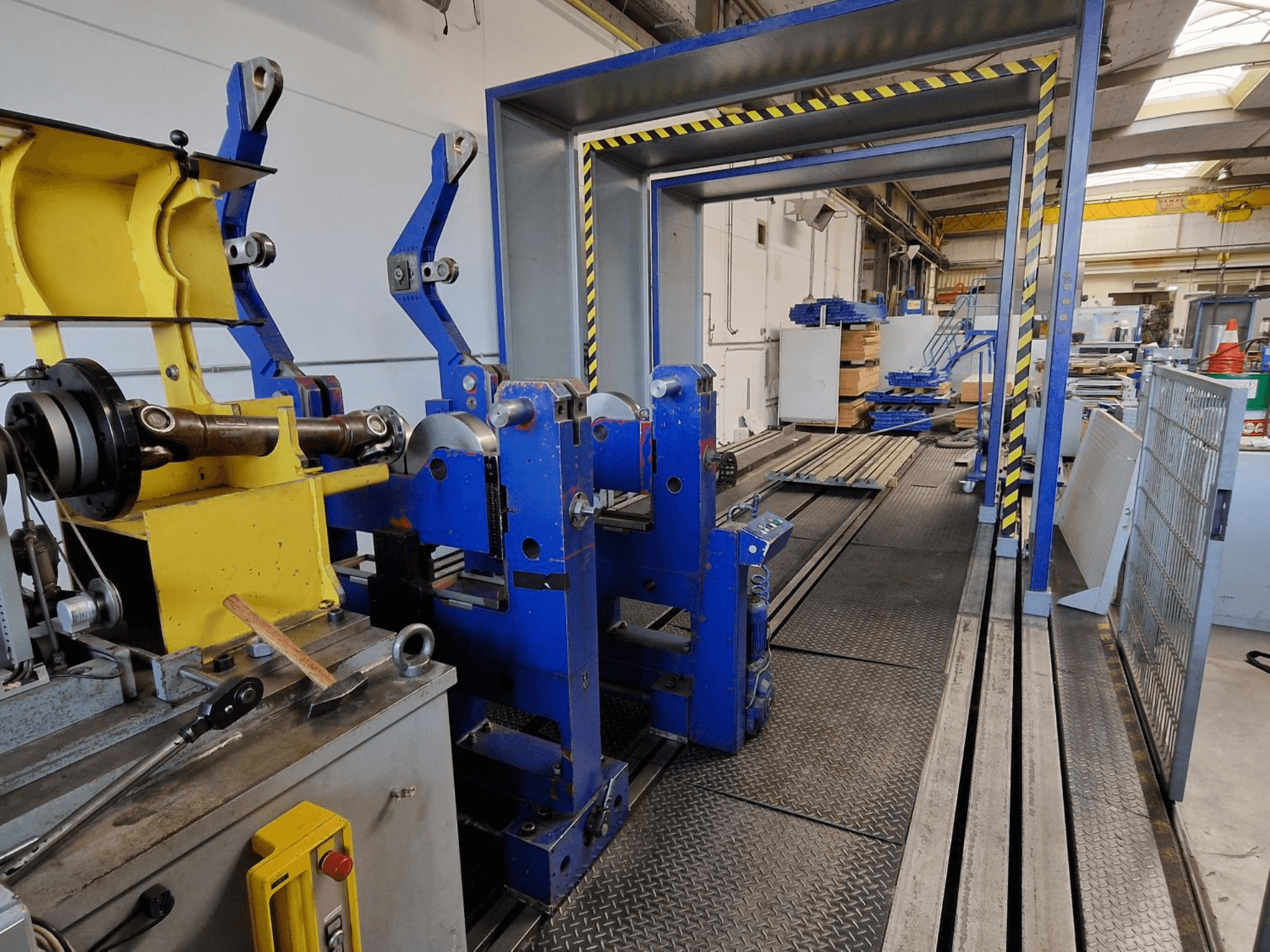 Máquina herramienta SCHENCK HM 70U BU, vista lateral en la que se aprecia la estructura azul con componentes amarillos y el panel de control en un entorno industrial.