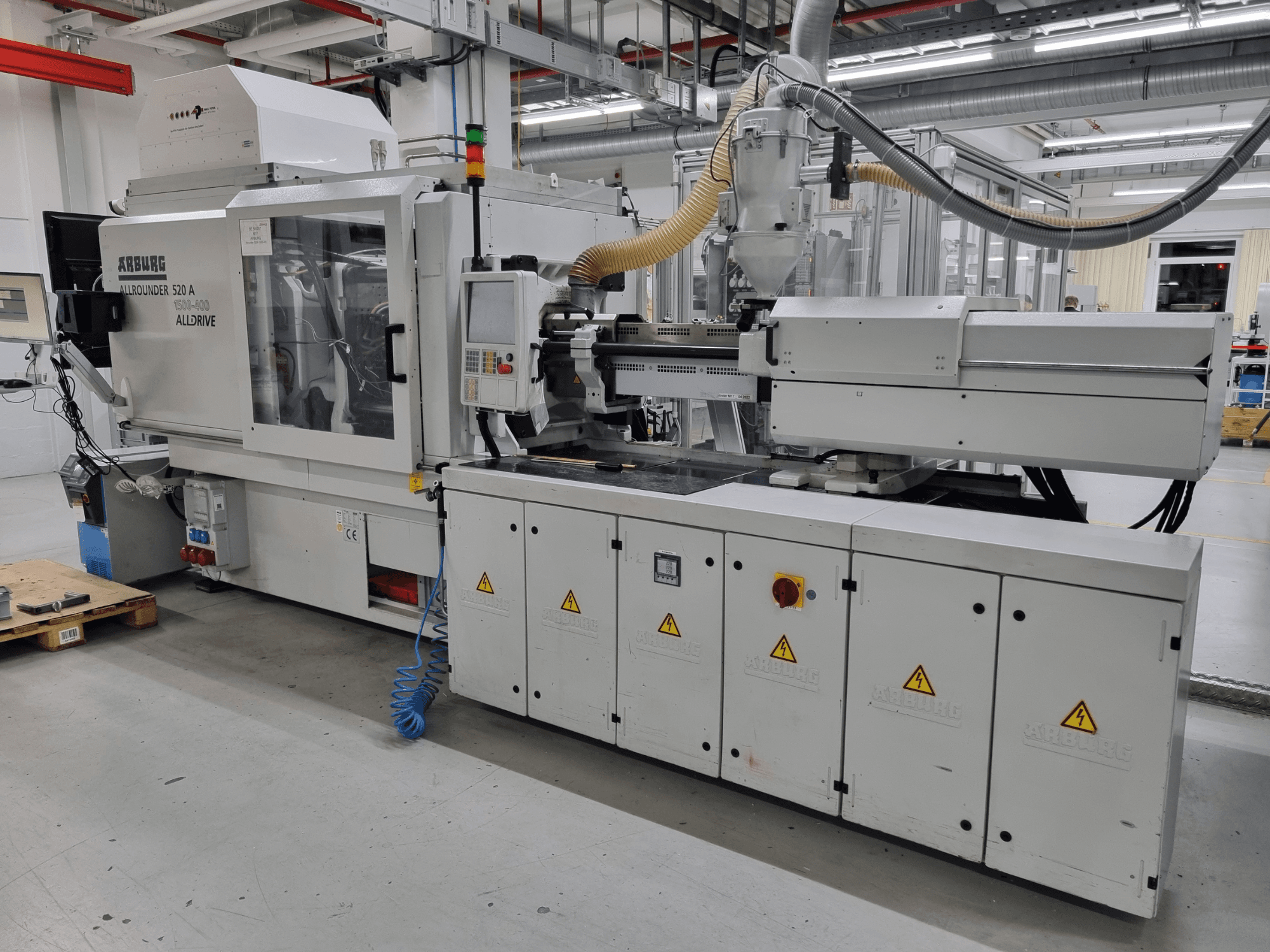 Máquina de moldeo por inyección Arburg Allrounder 520 A, vista lateral, mostrando el panel de control y las características de seguridad.