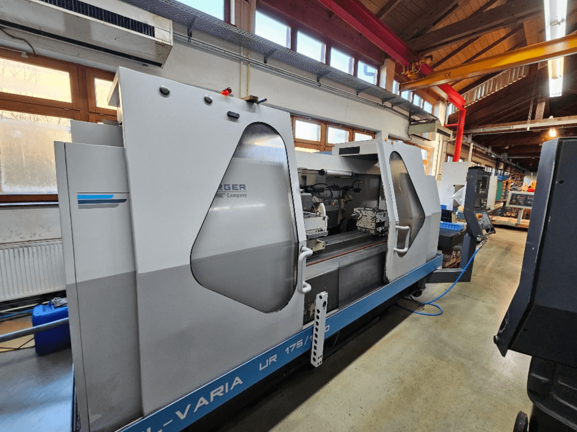 Máquina CNC de Burg, modelo UR 175/300, vista lateral. Presenta un diseño elegante con controles y área de trabajo visibles.