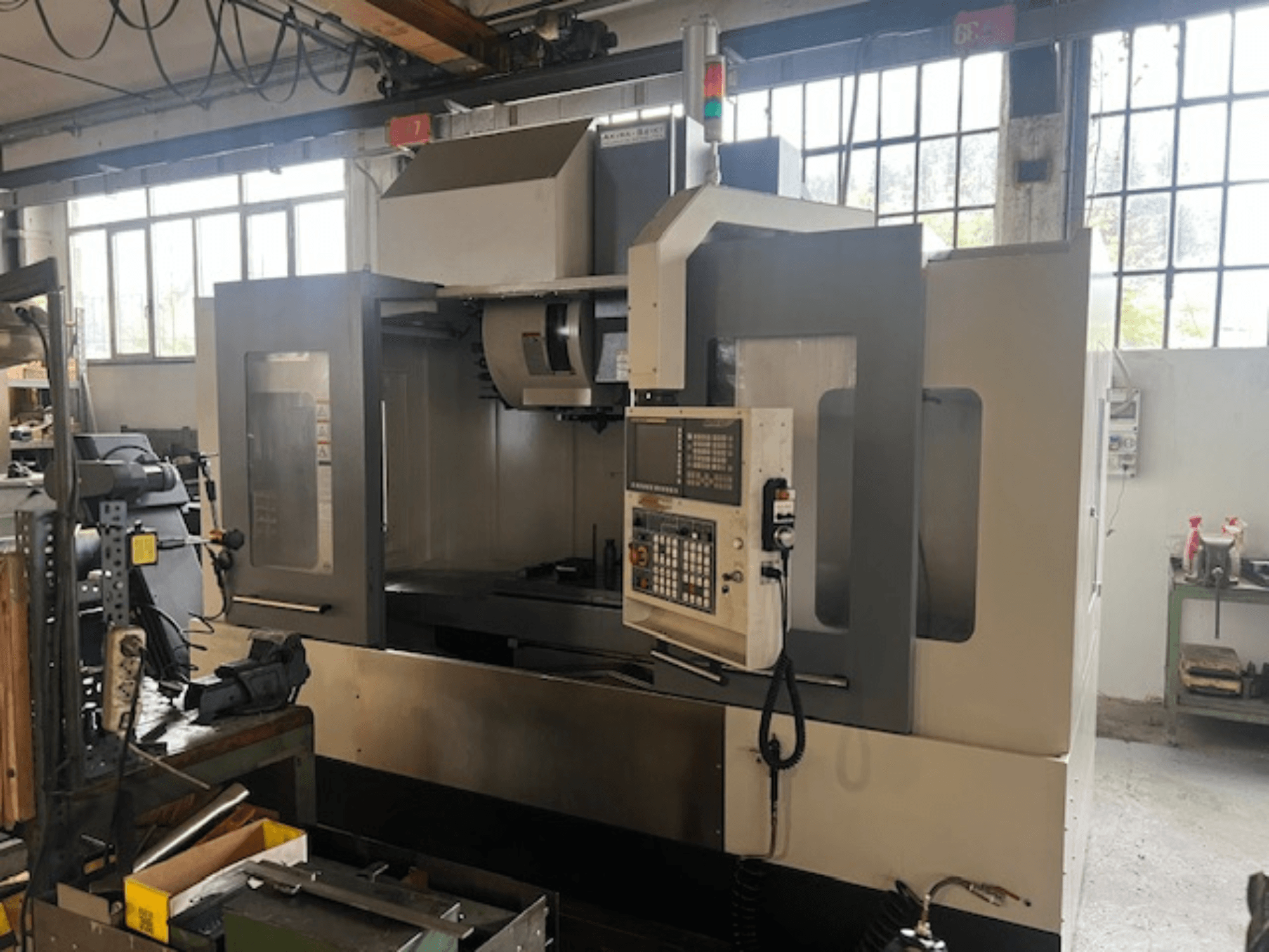 Fresadora CNC de alta tecnología, vista frontal, con controles digitales, indicadores básicos de seguridad y un diseño compacto.