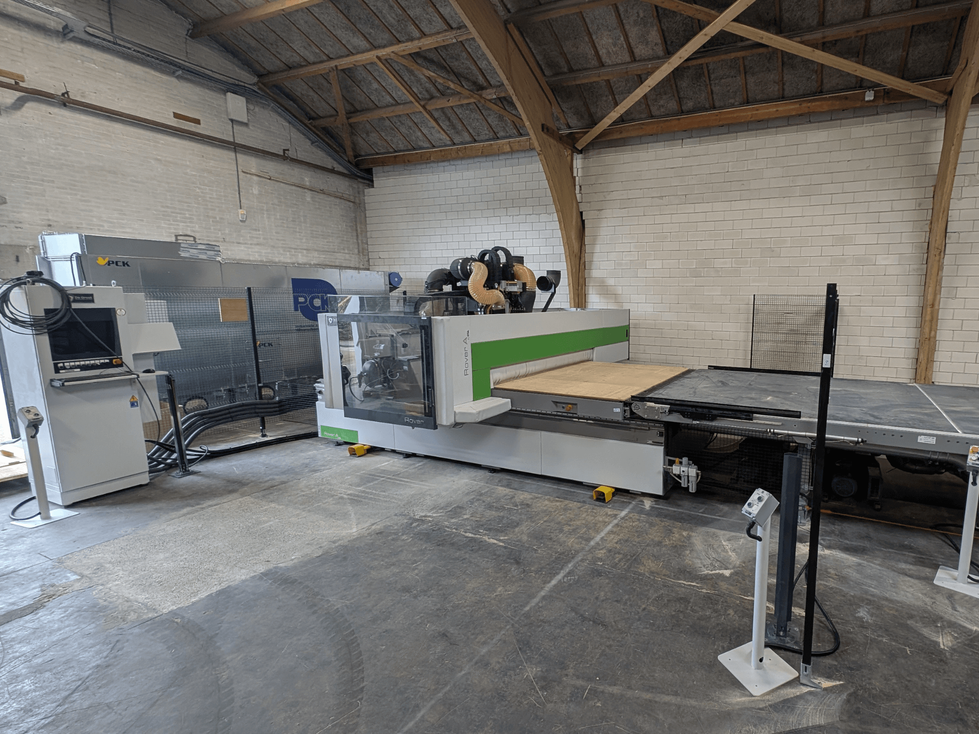 Centro de mecanizado CNC PCK, vista frontal, cuenta con una gran bancada de corte, panel de control, sistema de extracción de polvo y un diseño robusto.