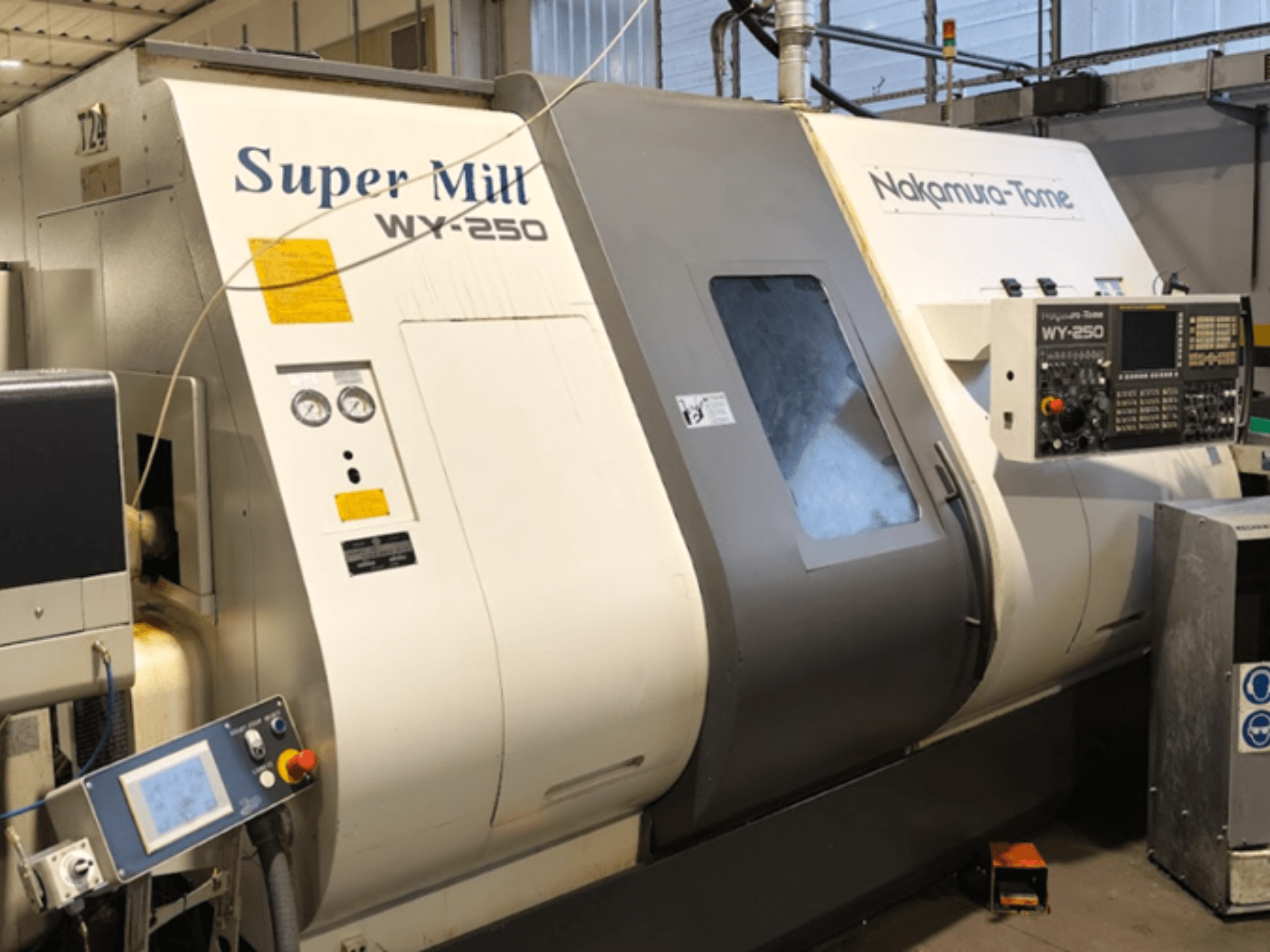 Máquina de torneado horizontal NAKAMURA-TOME WY 250 en vista frontal; dispone de panel de control y pantalla, con la etiqueta "Super Mill".