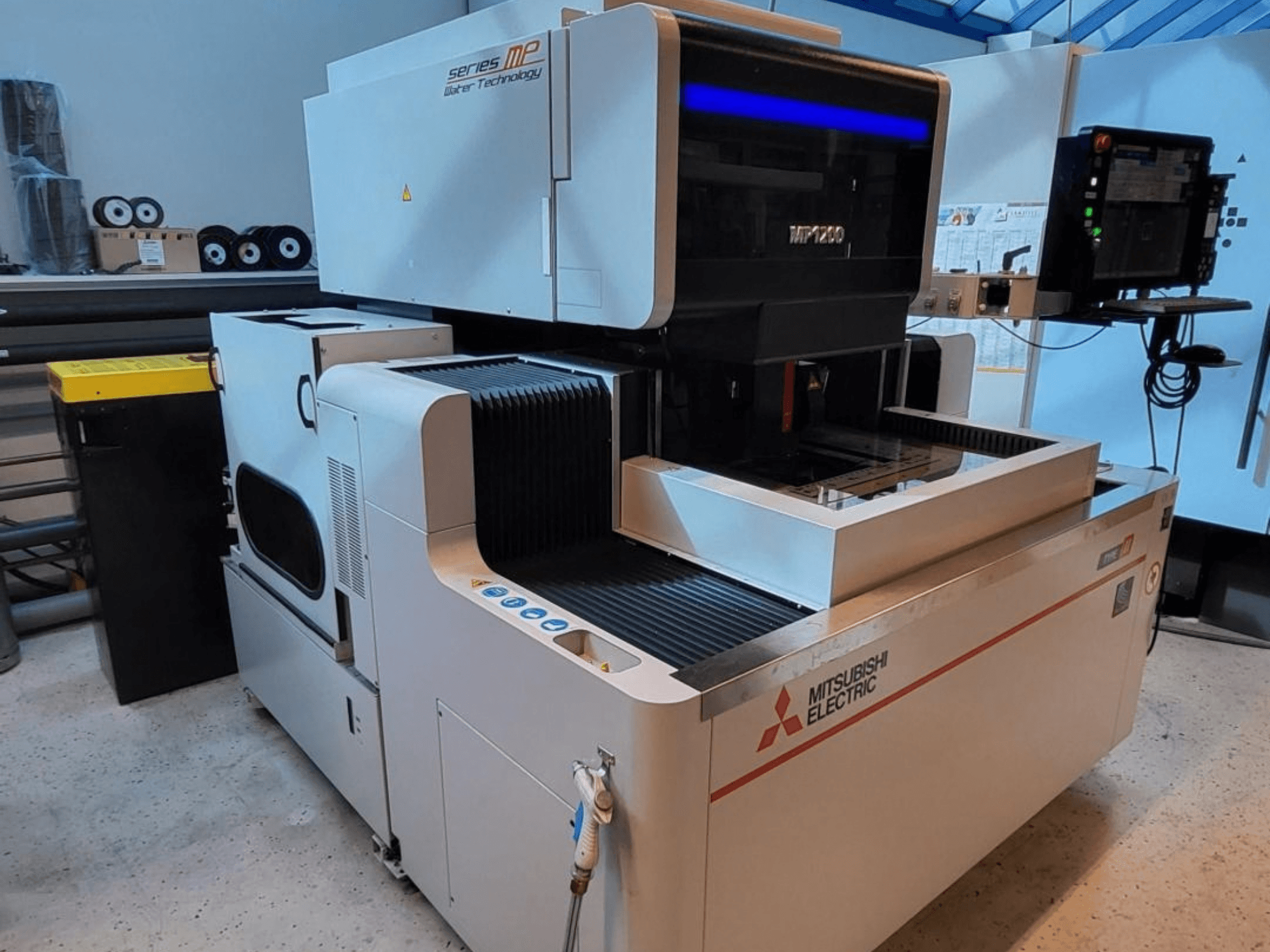 Máquina de electroerosión por hilo Mitsubishi MP1200, vista frontal, en la que destacan el panel de control, los detalles de alta tecnología y su elegante diseño.