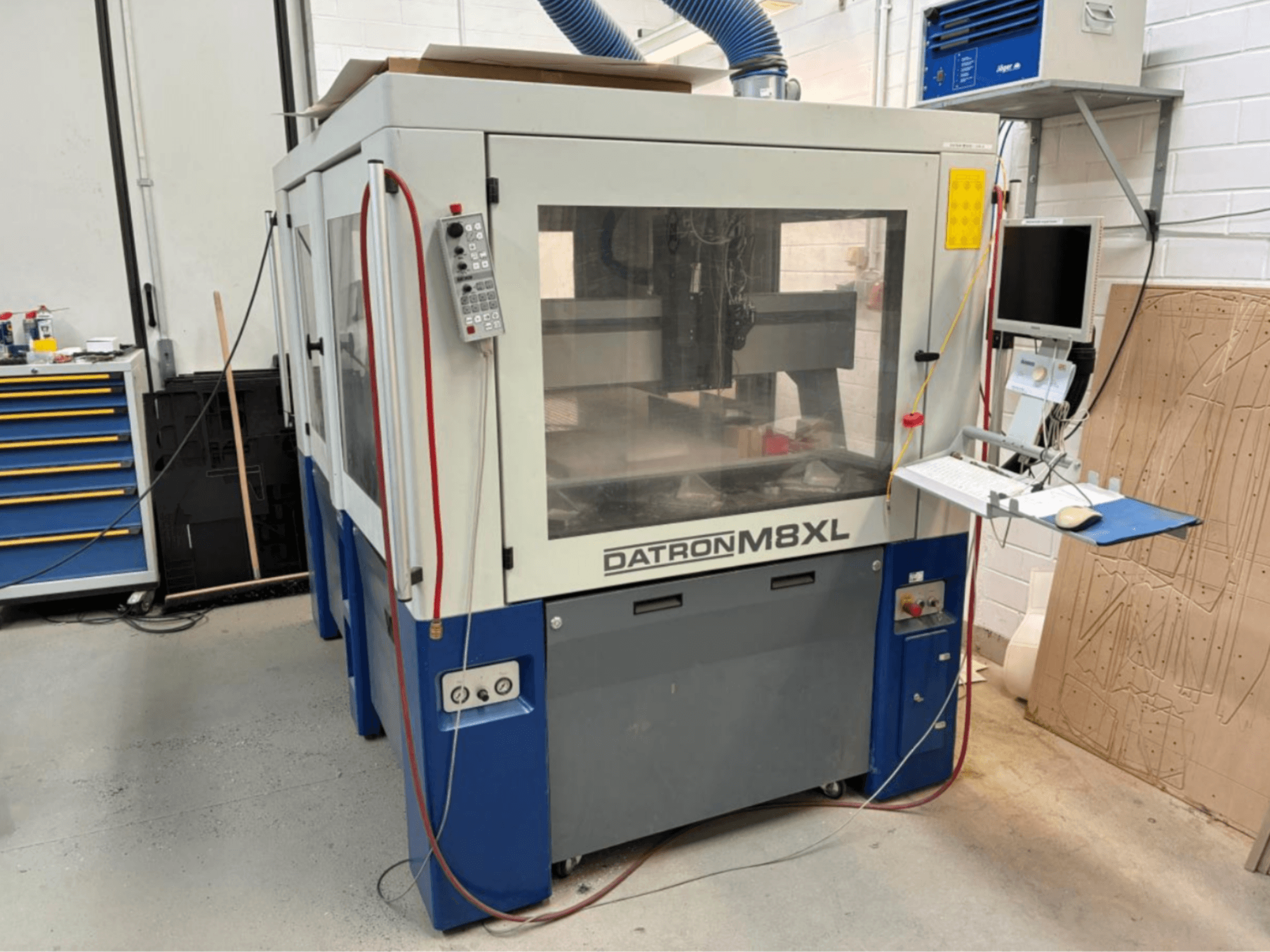 Máquina CNC DATRON M8XL en un taller, vista frontal con panel de control y monitor montados al lado.