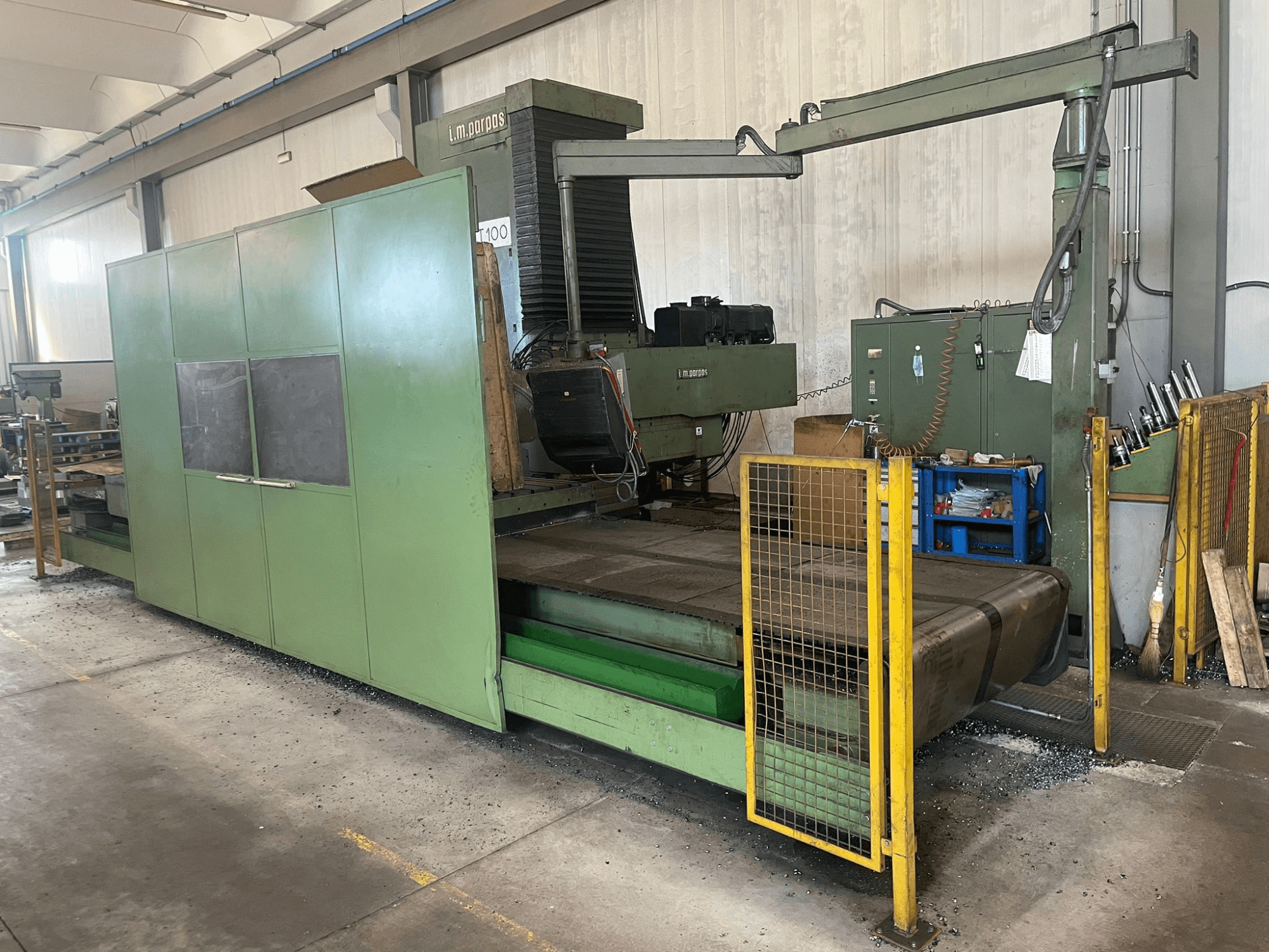 Gran fresadora industrial verde con barreras de seguridad, vista frontal, con etiqueta de modelo "l.m. parpas" y mandos visibles.