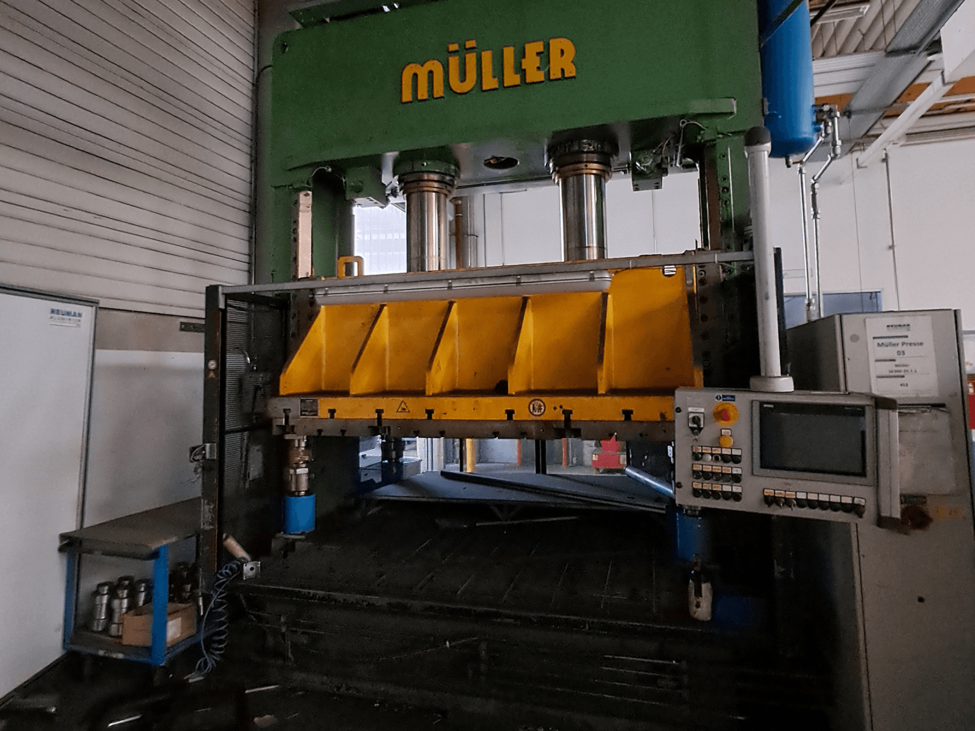 Vista frontal de una prensa para metal Müller SE 300-25.1.1, con los componentes de prensado en color amarillo y un panel de control en el lateral.