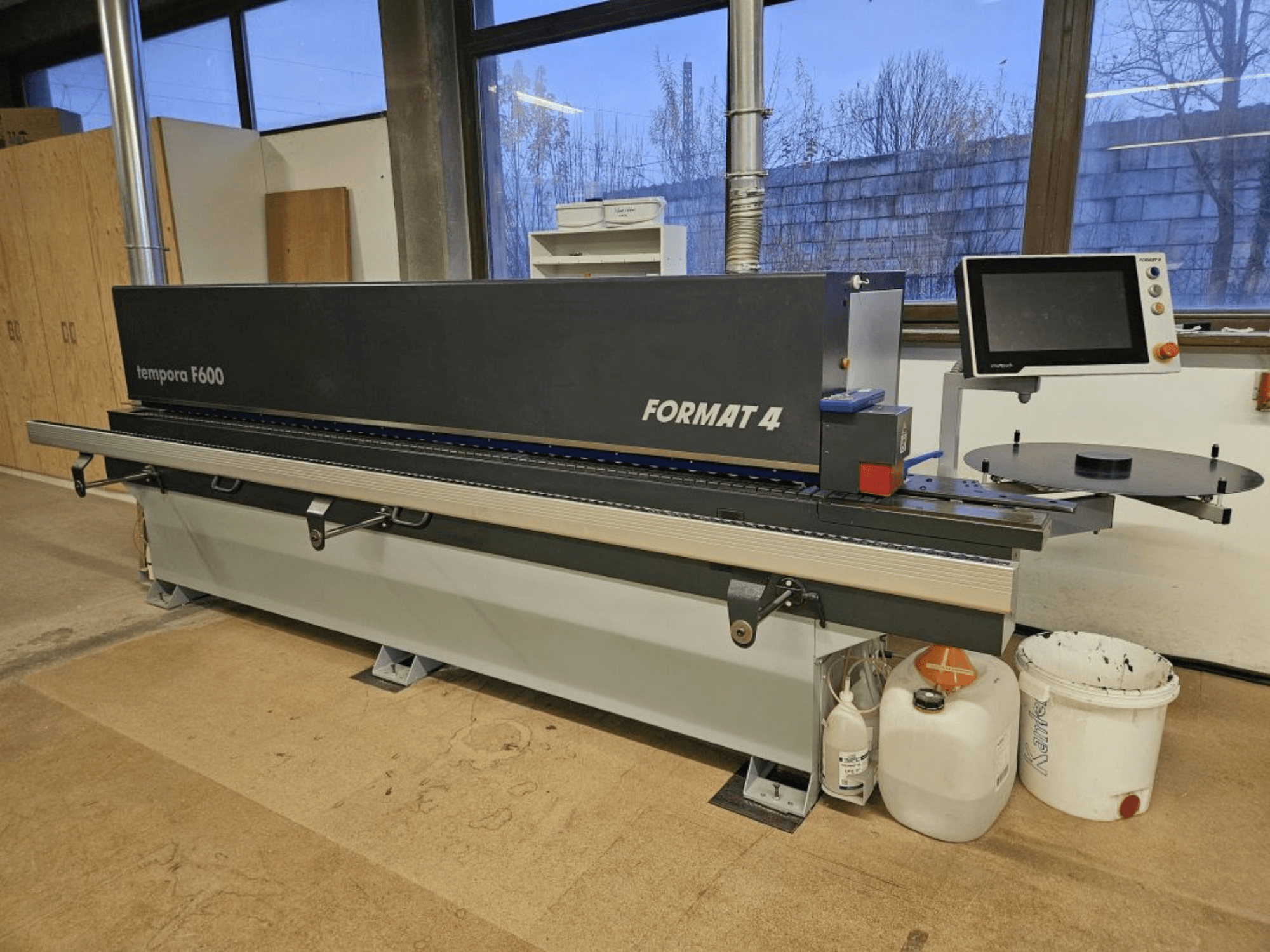 Templora F600 de Format 4, vista frontal de una máquina para trabajar la madera con pantalla digital, mesa de corte y contenedores de almacenamiento.