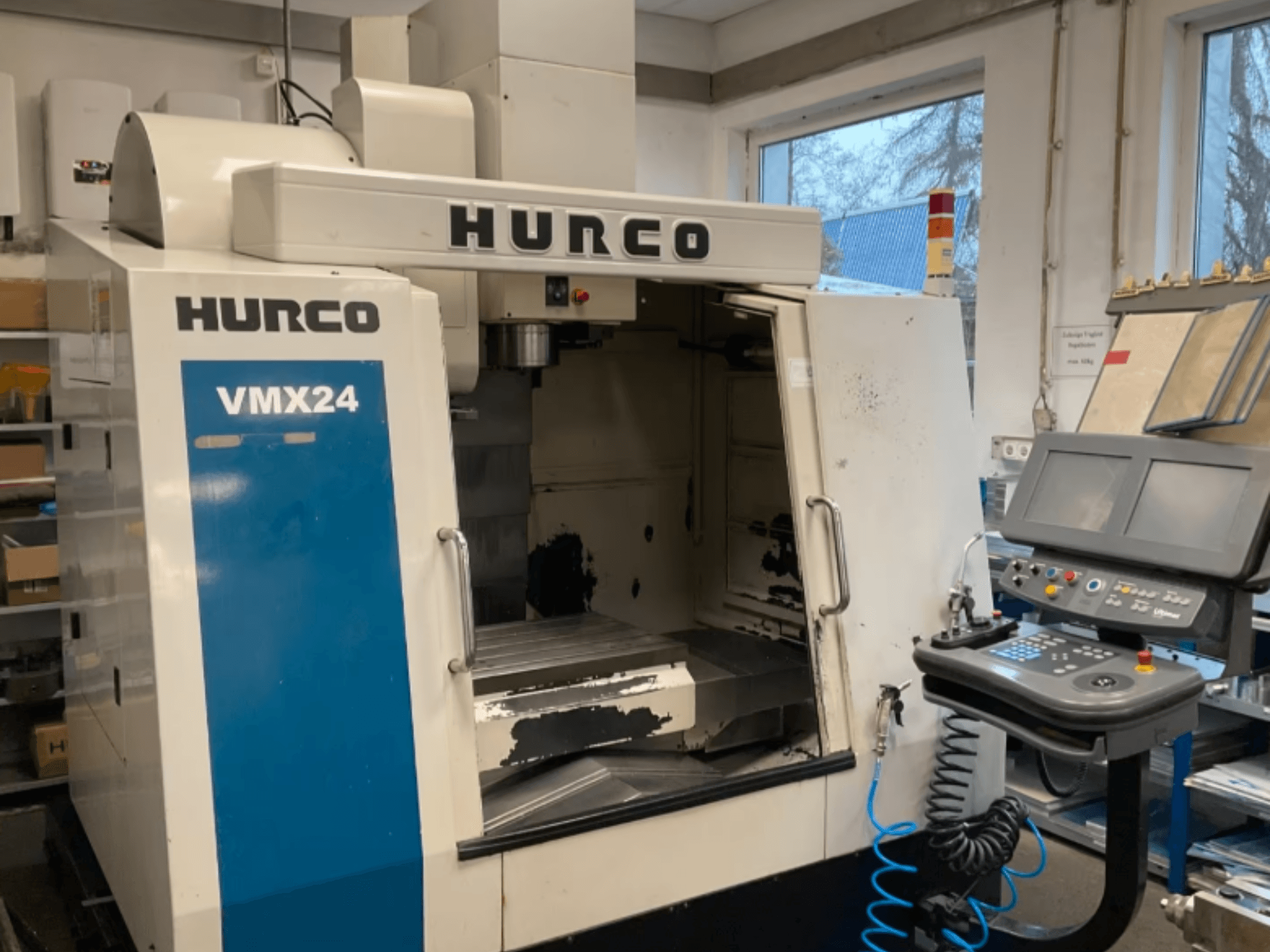 Centro de mecanizado vertical Hurco VMX24 visto de frente, en el que se aprecian el panel de control, el cabezal del husillo y la zona de trabajo, con algunos signos visibles de desgaste.