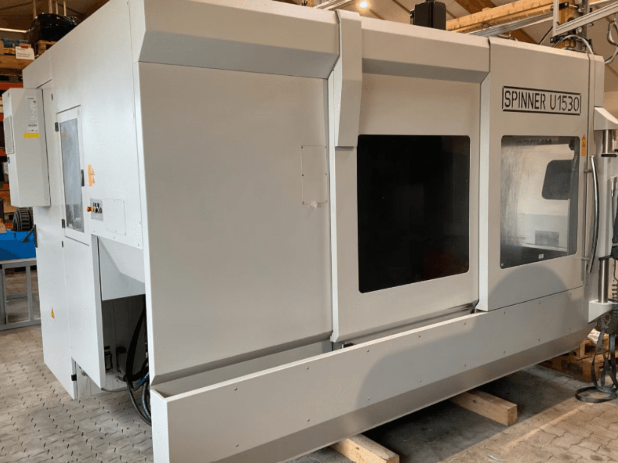 Centro de mecanizado vertical SPINNER U5-1530 visto de perfil, con una amplia zona de trabajo y un panel de control.