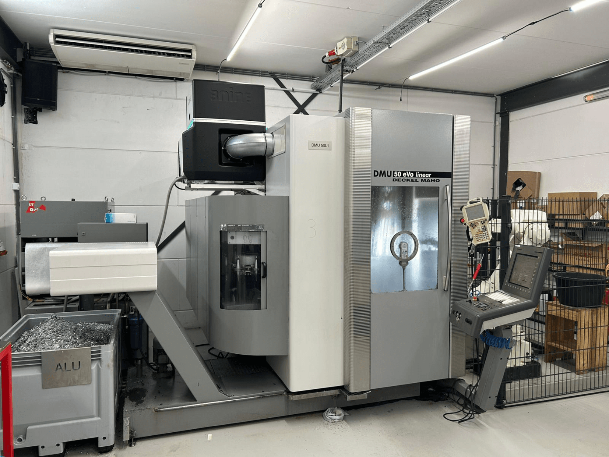 Fresadora lineal DMU 50 eVo de Deckel Maho, vista frontal, con panel de control y contenedor de virutas.