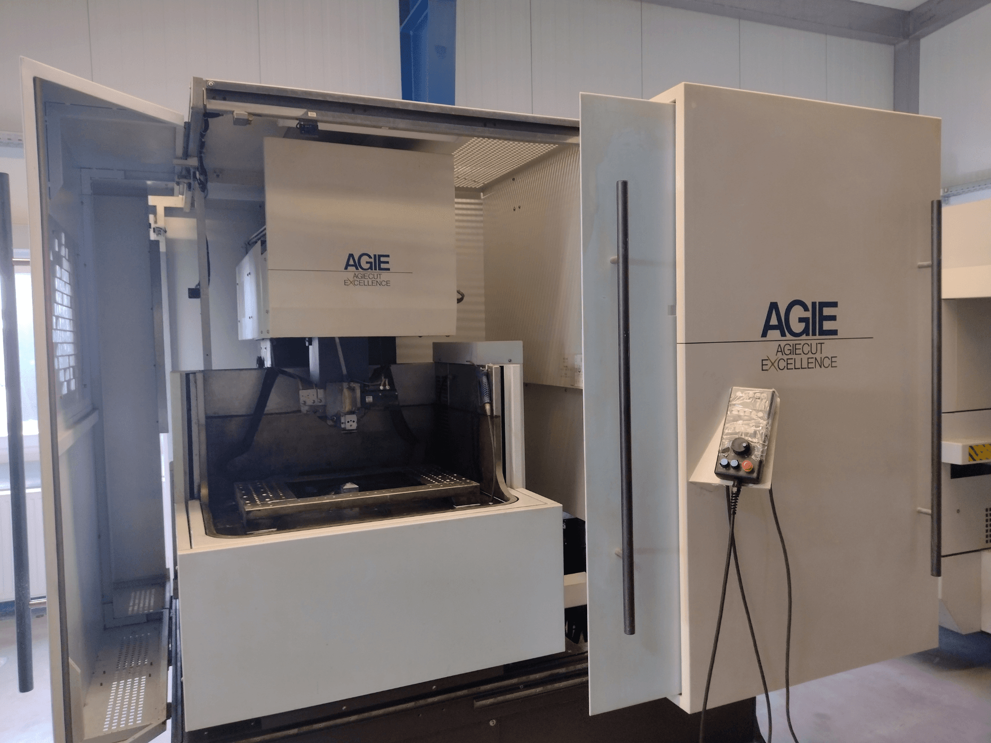 Máquina de electroerosión por hilo AGIE Progress 3, vista frontal, en la que se aprecian la cabina abierta, el panel de control y la zona de corte.