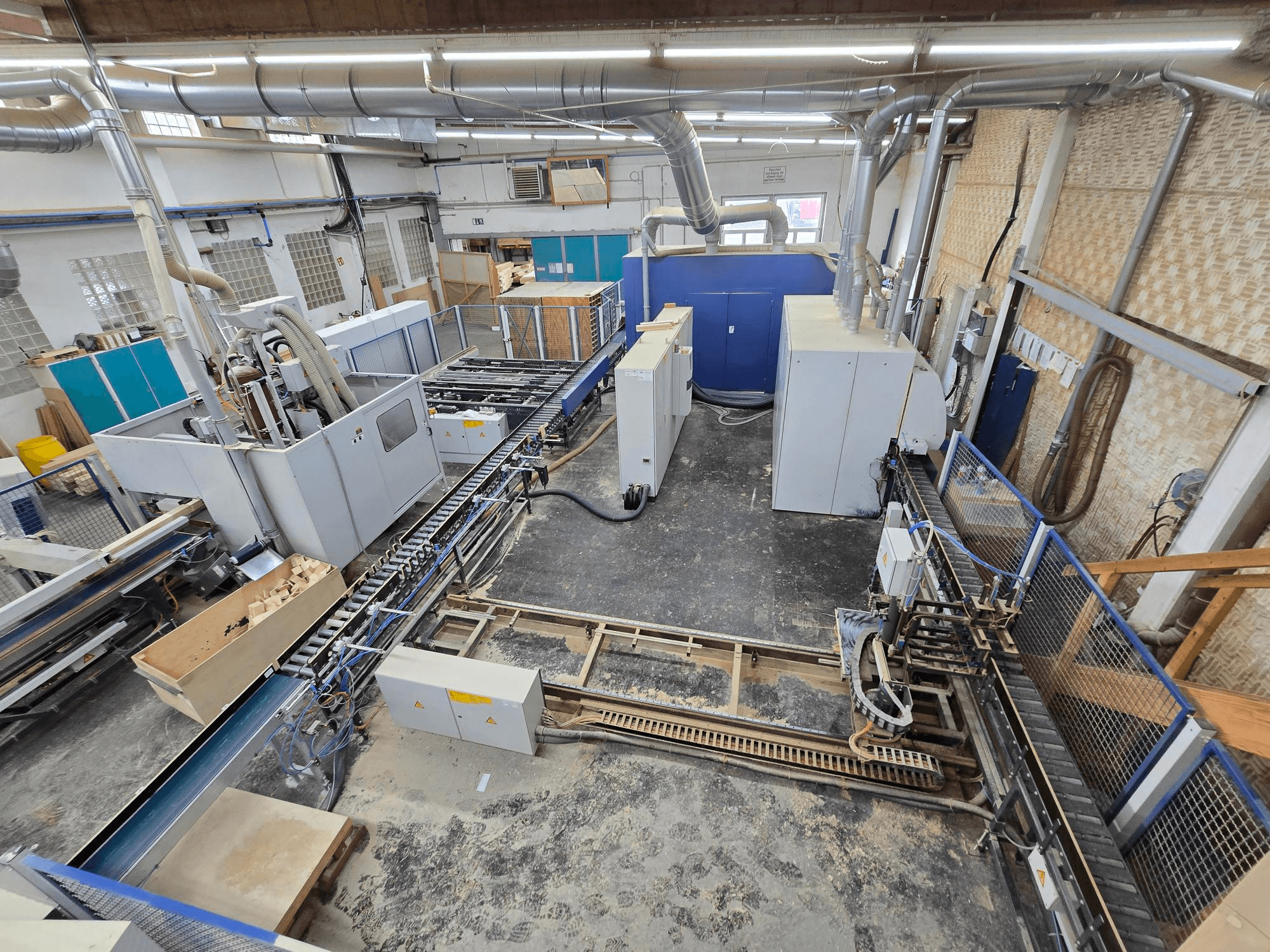 WEINIG DIMTER Unirex 2000 SPB línea completa de producción de madera en un entorno de fábrica, vista aérea que muestra la maquinaria y el sistema de transporte.