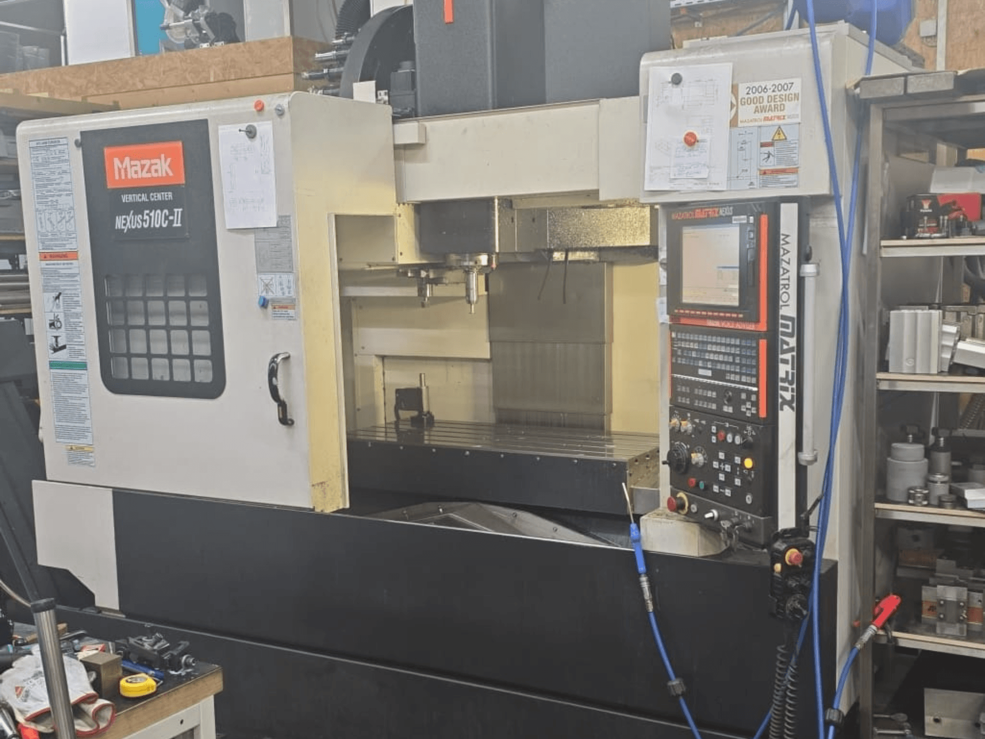 CENTRO VERTICAL NEXUS 510C-II de Mazak, vista frontal que muestra el panel de control, el área de mecanizado y las características operativas.