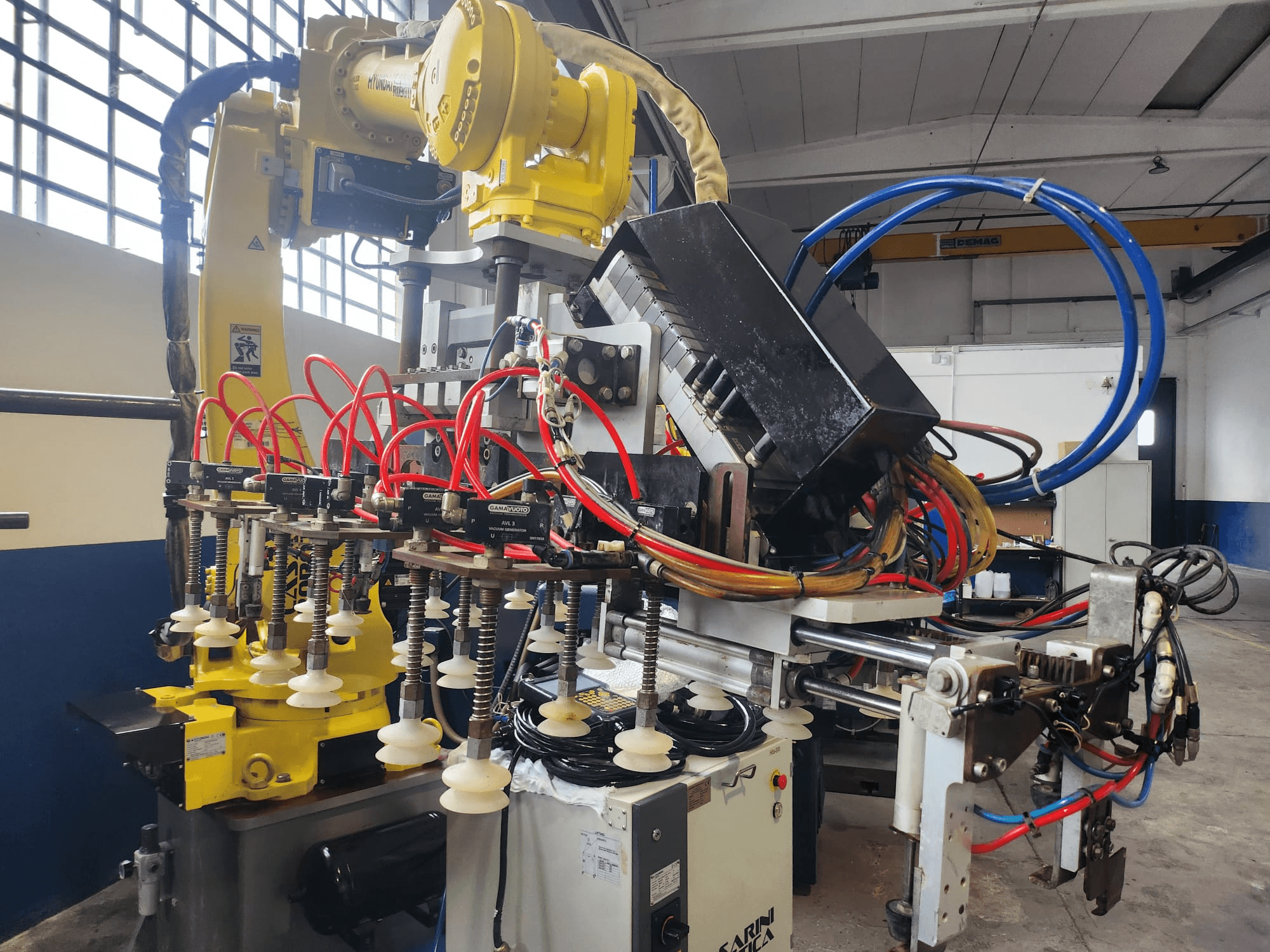 Brazo robótico Hyundai Hi 5a-S desde una vista frontal, con múltiples mangueras, componentes de control y una compleja disposición de cables.