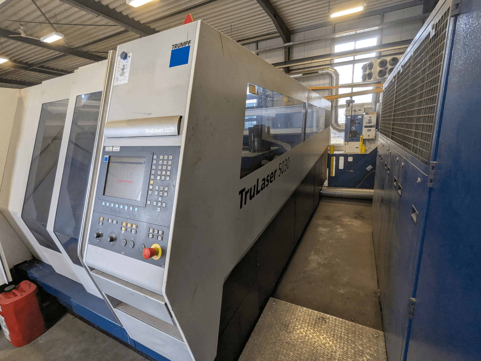 Máquina de corte por láser de CO2 TRUMPF TruLaser 5030, vista frontal con panel de control y diseño elegante, en entorno industrial.