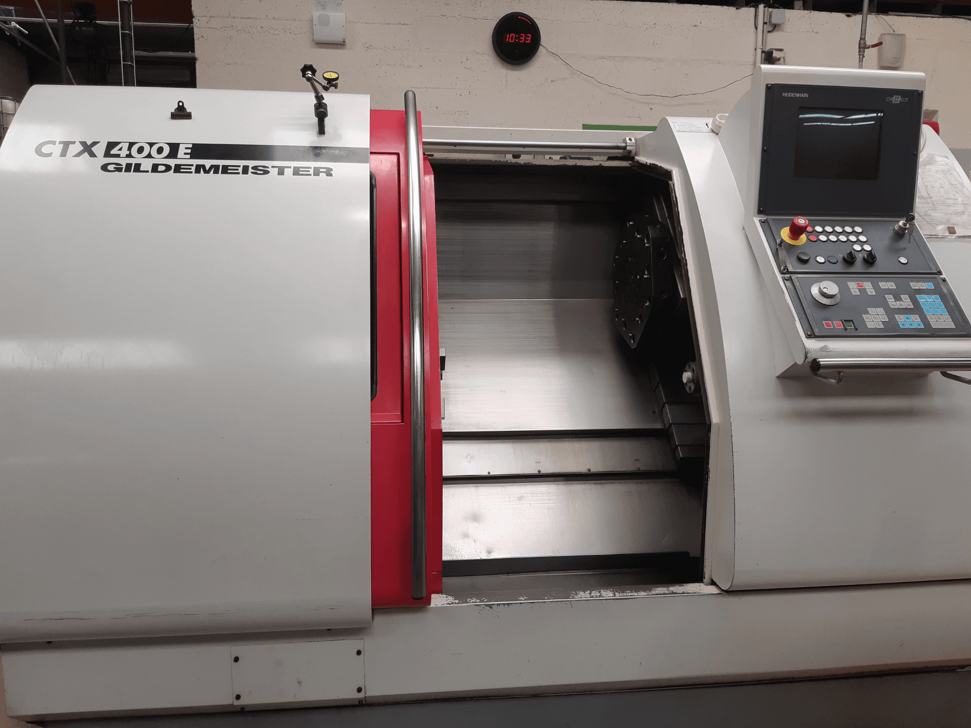 Torno horizontal Gildemeister CTX 400 E visto de perfil, en el que se aprecian el panel de control y la parte delantera abierta para acceder a las herramientas.