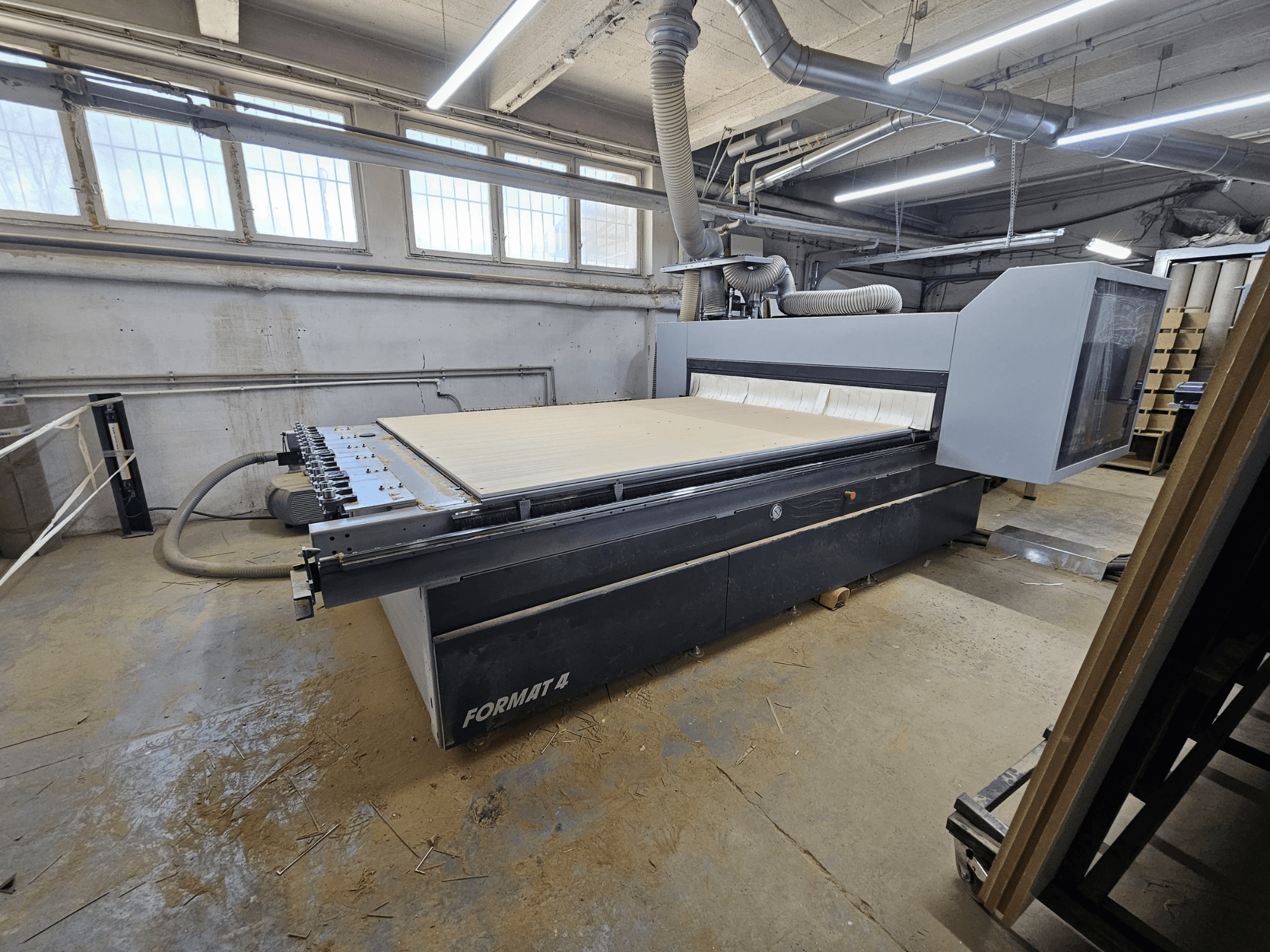 CNC Router FORMAT4 Profit H80 21.31, vista lateral que muestra la gran mesa de trabajo y el panel de control en un entorno de taller.