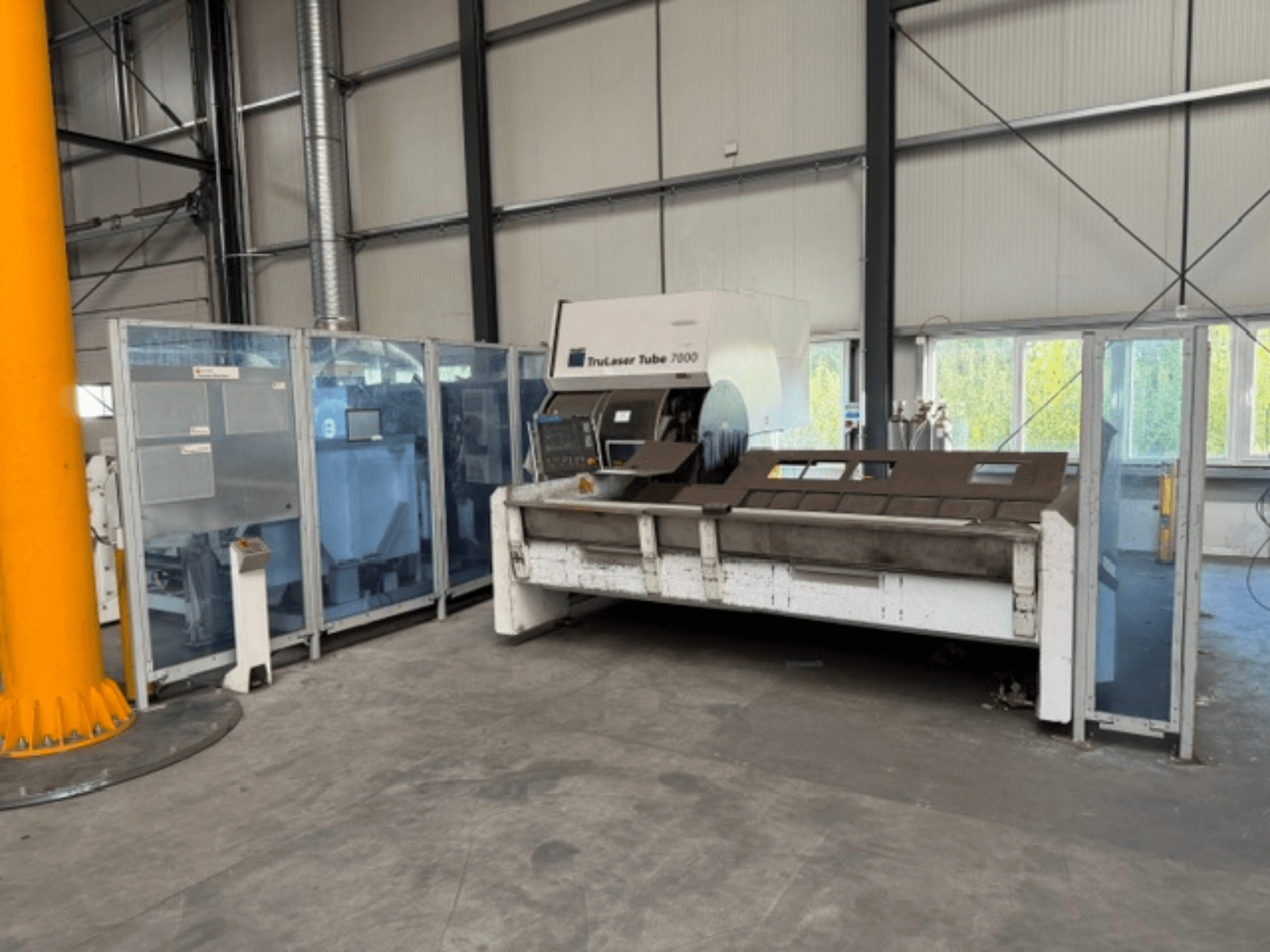 TruLaser Tube 7000 de TRUMPF: vista frontal de una máquina de corte de tubos en un entorno industrial bien iluminado, con los mandos de control a la vista.