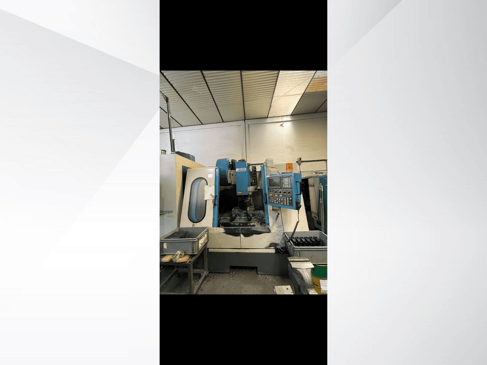 Máquina CNC, modelo Challenger 1500, vista lateral que muestra el panel de control y el espacio de trabajo con virutas de metal.