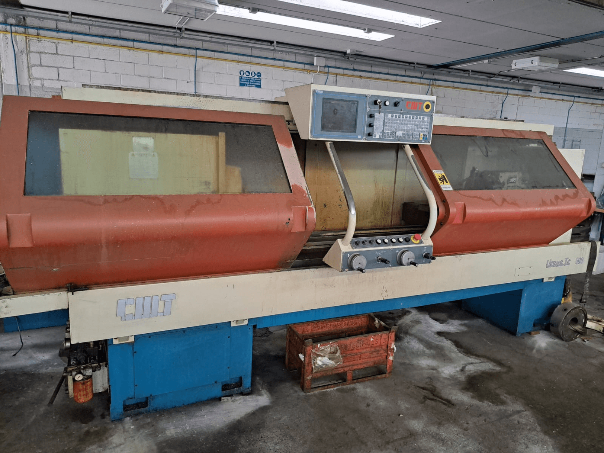 Torno horizontal URSUS TC, vista frontal, con carcasa roja, panel de control y portaherramientas visible.