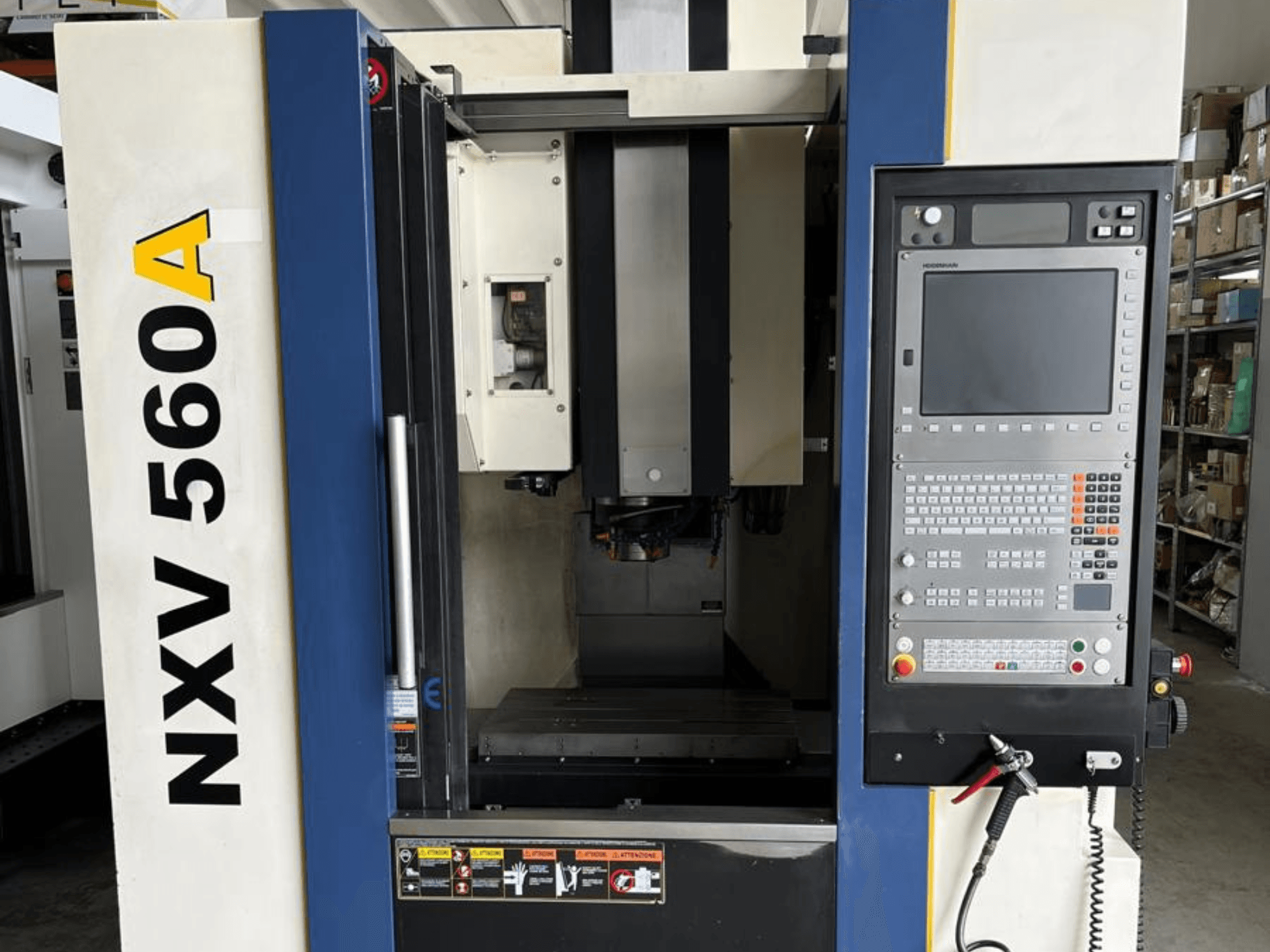 Máquina CNC NXV 560A vista de frente, con panel de control con botones y pantalla digital.