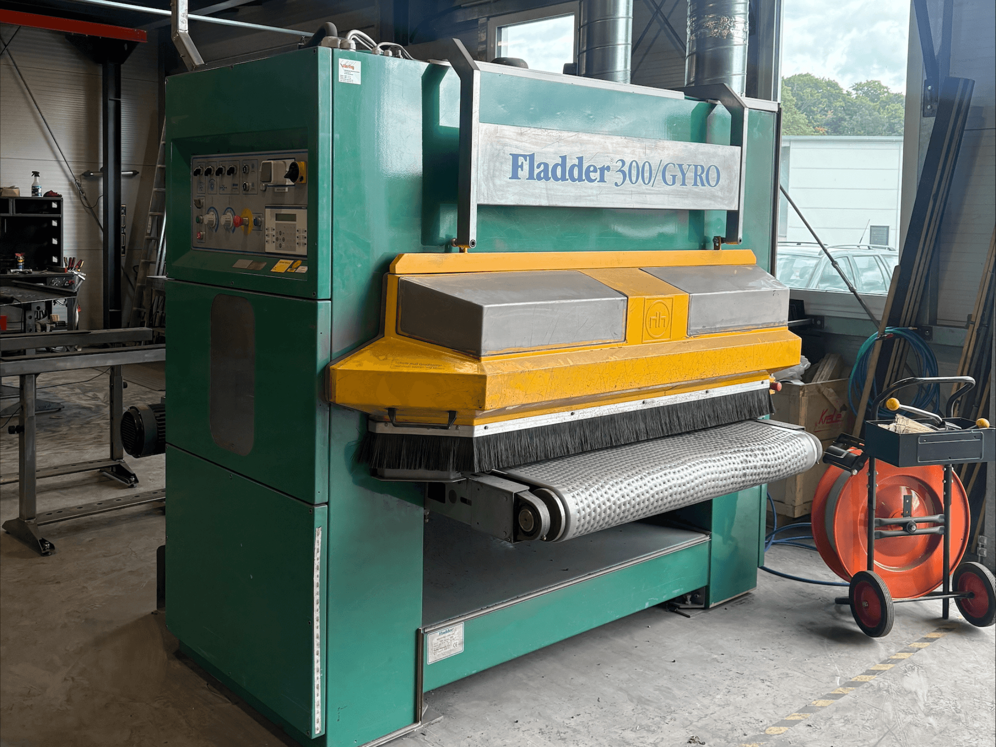 Lijadora industrial Fladder 300/GYRO en verde y amarillo, vista frontal, con panel de control y tambor de lijado.