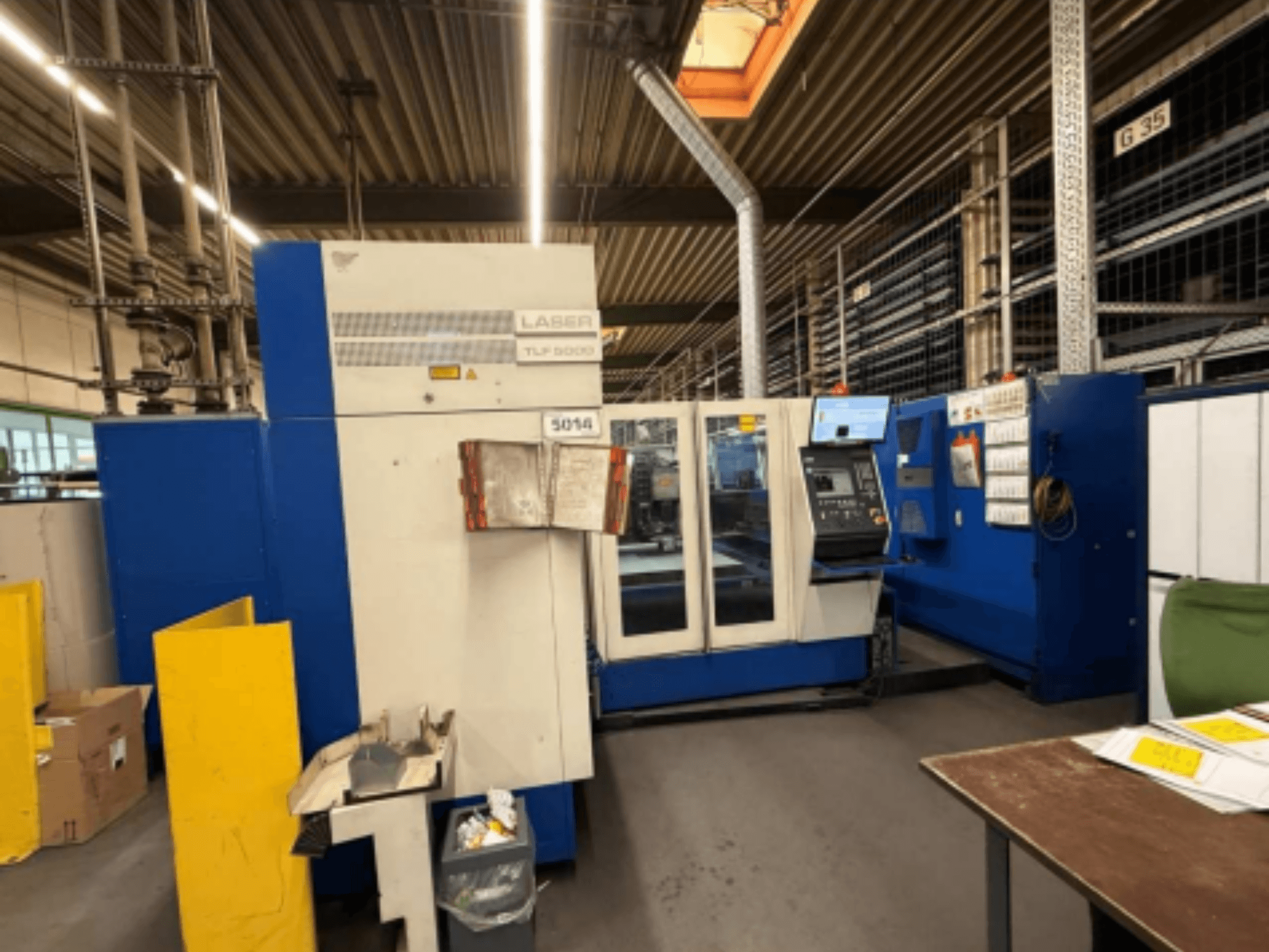 Vista frontal de la máquina de corte por láser de CO2 TRUMPF Trumatic L 3050, mostrando el panel de control y las características operativas en un taller.