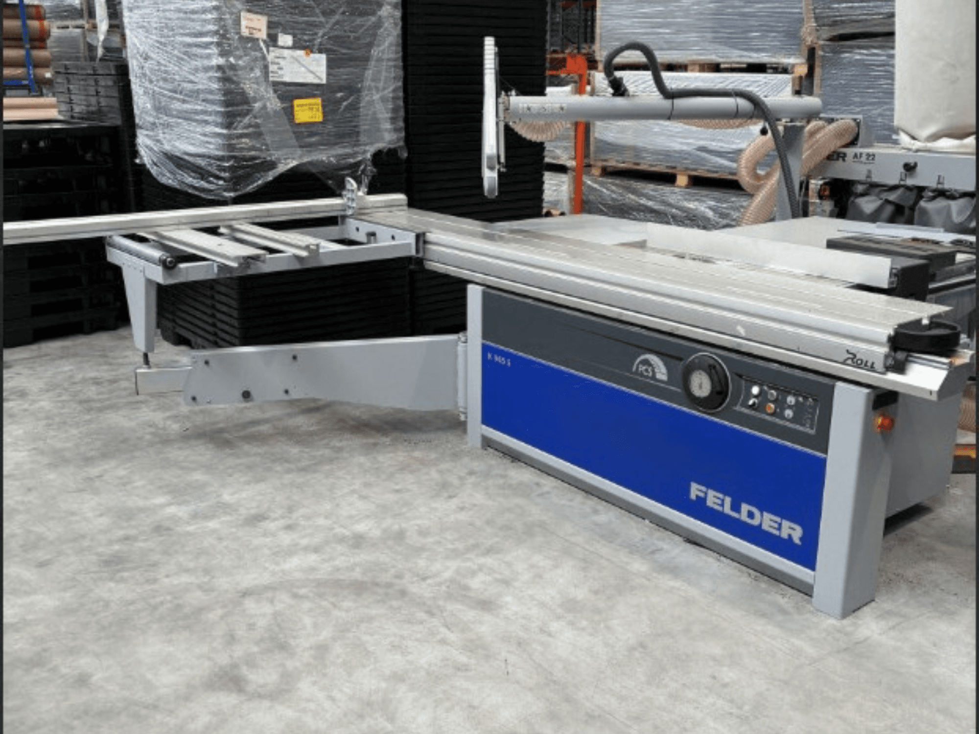 Sierra de paneles FELDER K 945S, vista frontal con mesa ajustable y panel de control, instalada en un almacén.
