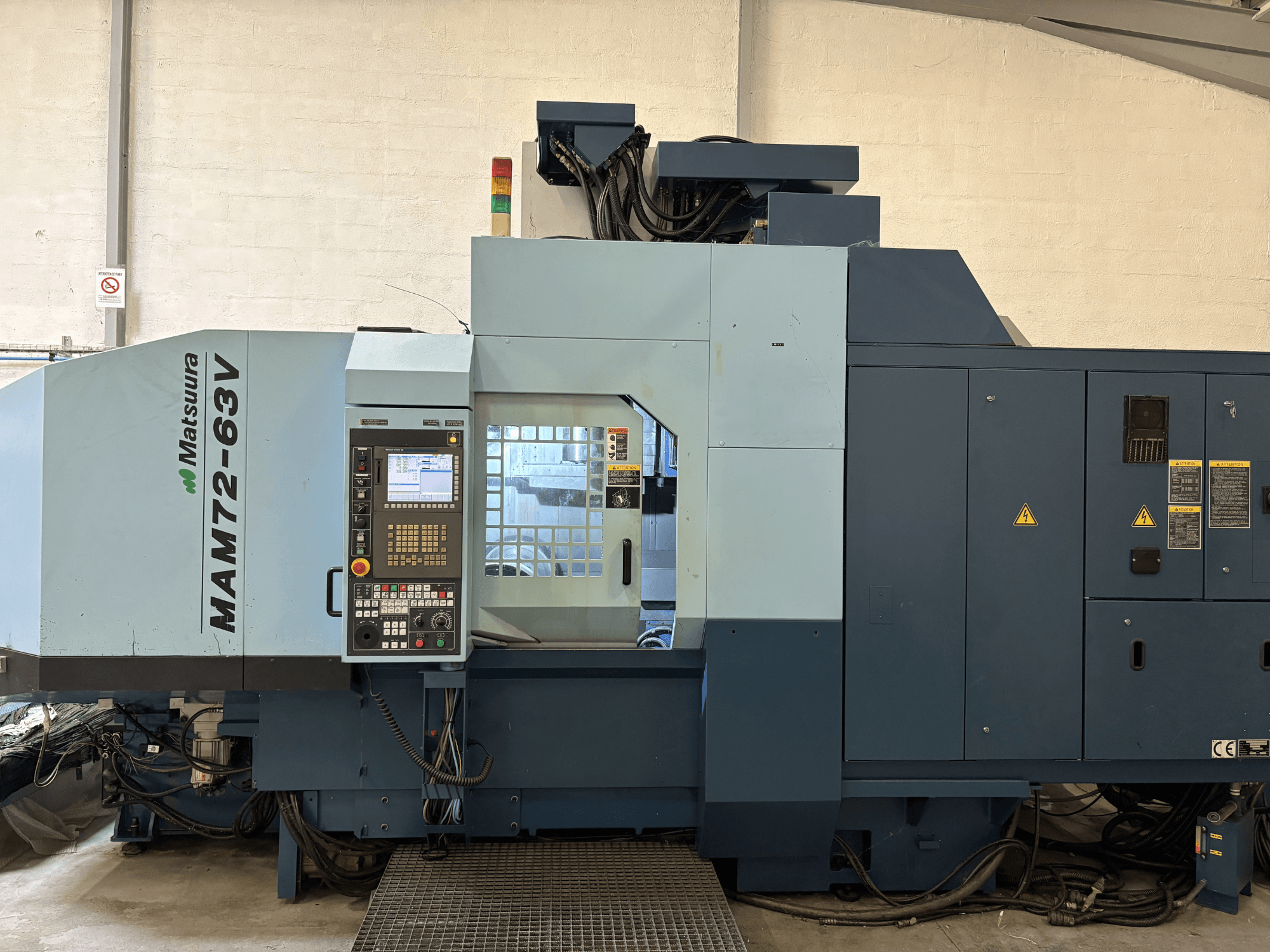 Centro de mecanizado vertical Matsuura MAM 72-63 V, vista frontal con panel de control y dispositivos de seguridad.