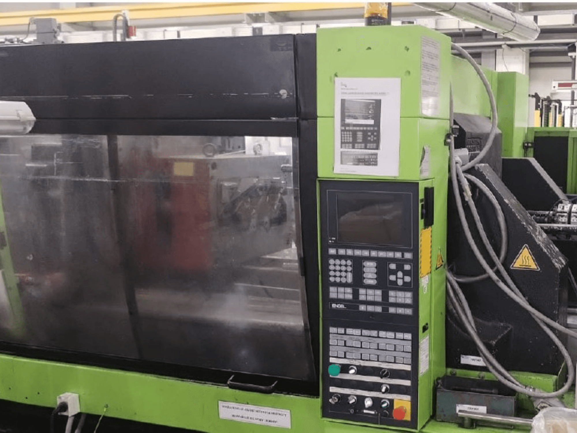 Máquina de moldeo por inyección hidráulica Engel ES 1050/275 HL-V; vista lateral en la que se aprecian el panel de control y los detalles de funcionamiento.