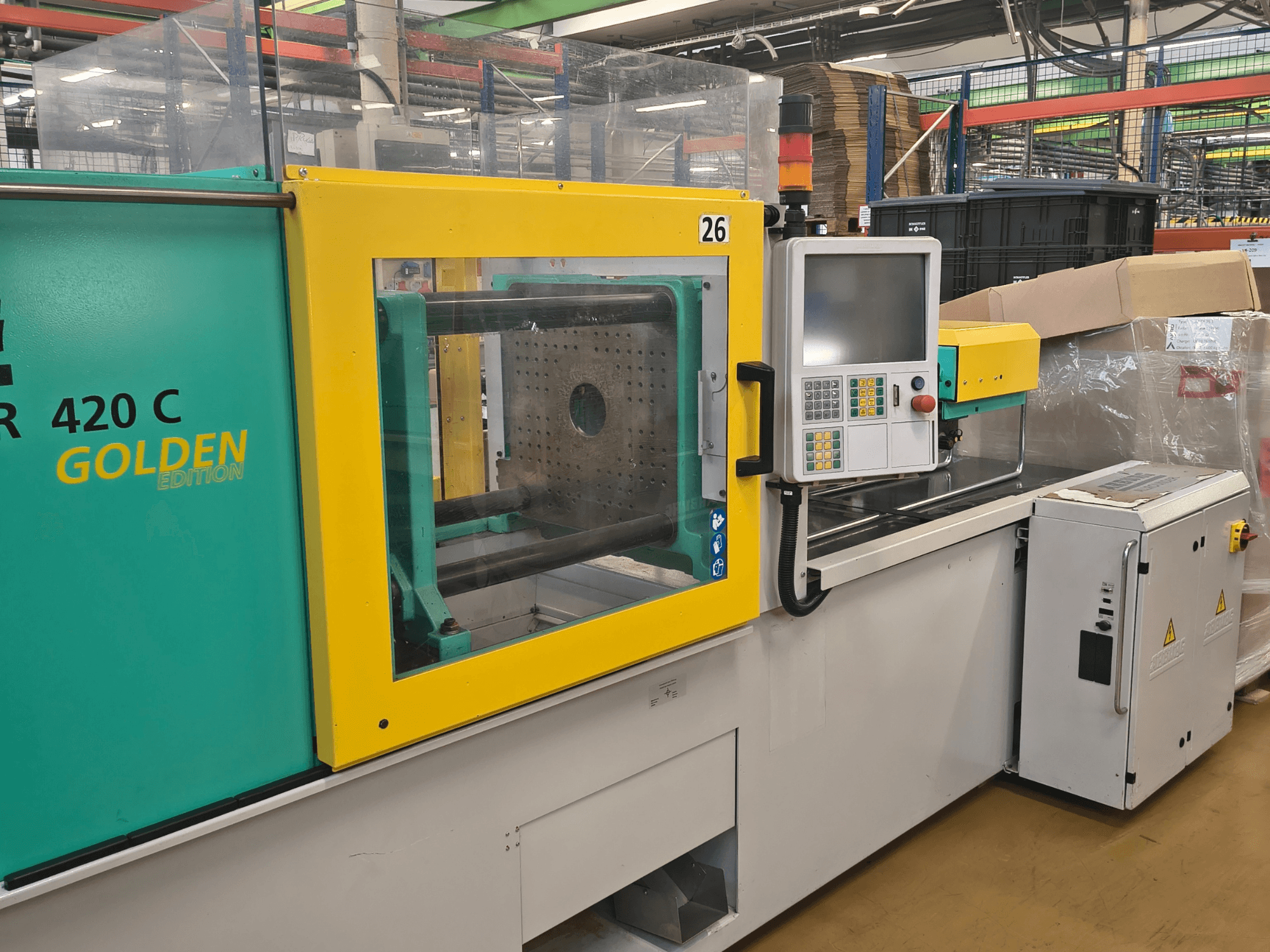 Máquina de moldeo por inyección, ARBURG 420 C Golden Edition, vista frontal; dispone de panel de control, protección de seguridad transparente y espacio de trabajo circundante.