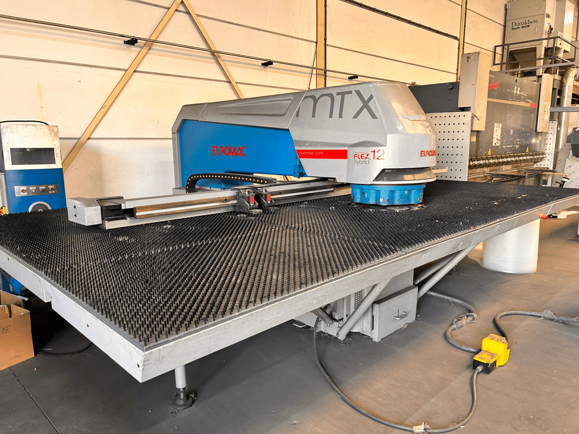 Punzonadora CNC Euromac MTX FLEX 12, vista frontal, con una amplia mesa perforada y un panel de control.