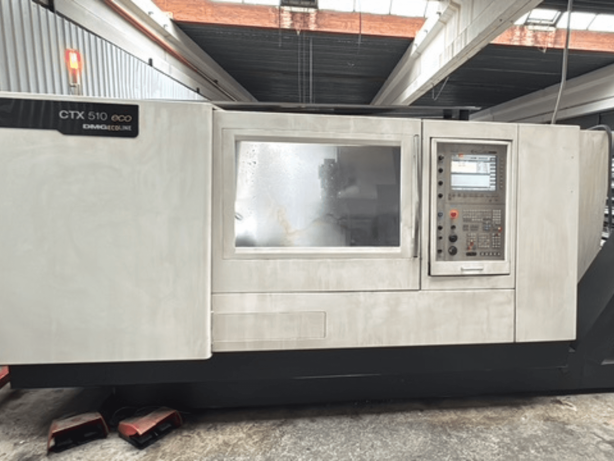 Torno horizontal DMG CTX 510 ecoline, vista frontal, en la que se aprecian el panel de control y la ventana del cuerpo de la máquina.