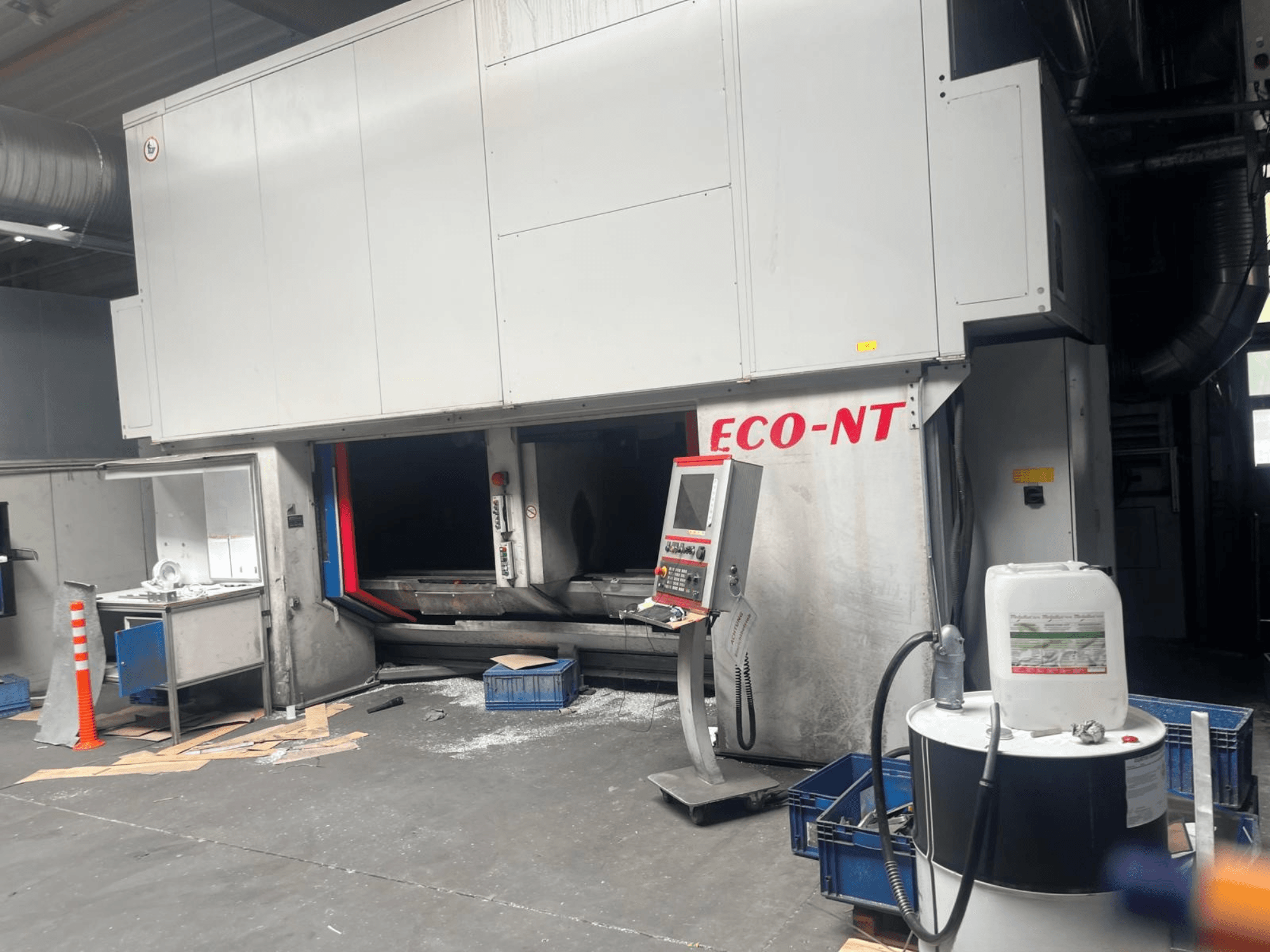 Vista frontal del centro de mecanizado vertical ECO-NT de Hamuel Reichenbacher, en la que se aprecian el panel de control, el depósito de líquido refrigerante y el espacio de trabajo.