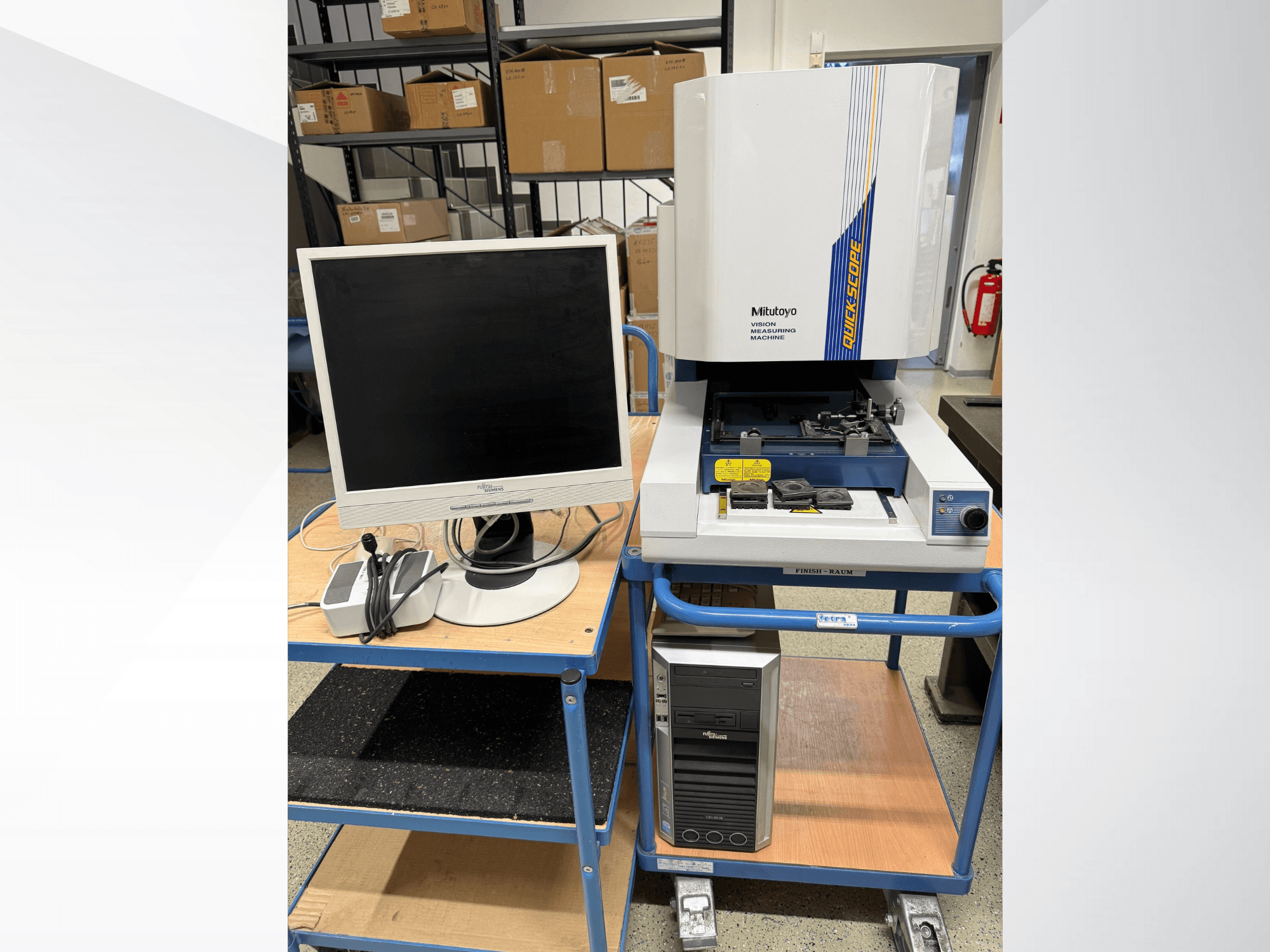 Máquina de medición por visión Mitutoyo Quick Scope con monitor, PC y accesorios, vista frontal, en un carro azul.