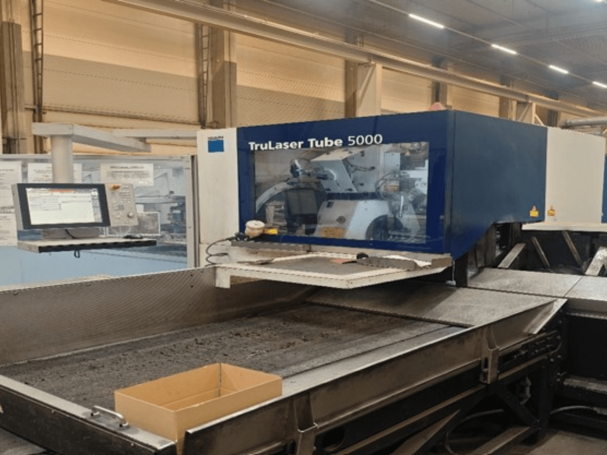 TRUMPF TruLaser Tube 5000 en vista frontal, en la que se aprecian el panel de control y la zona de corte para operaciones precisas de corte de tubos.