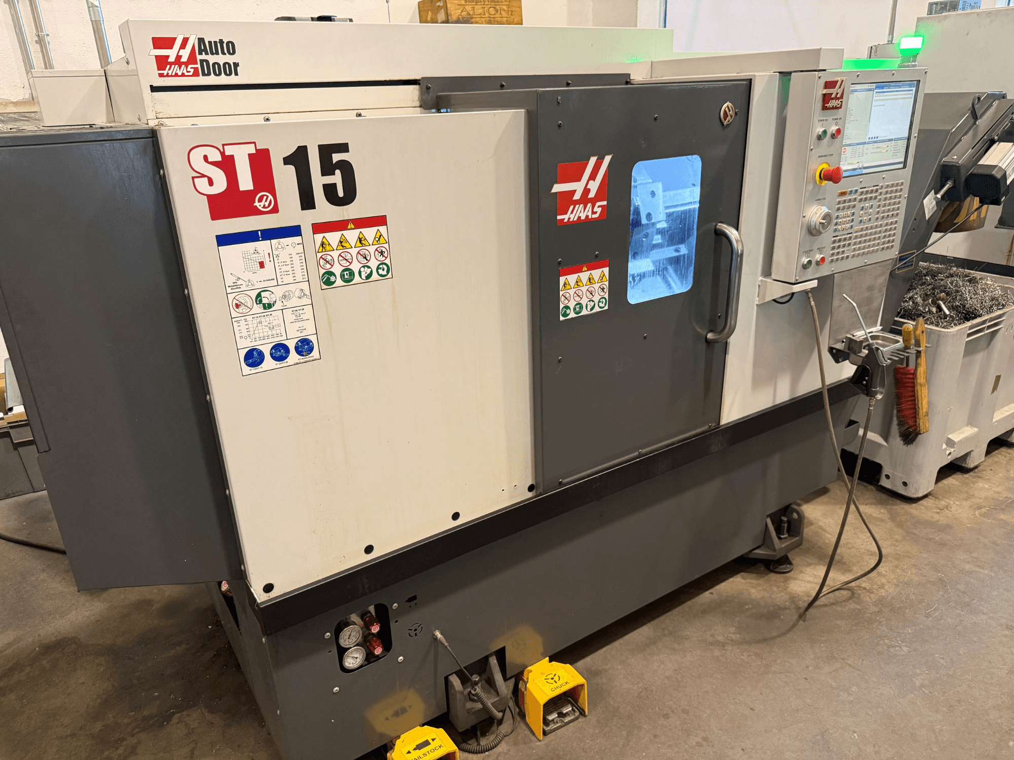 Torno horizontal HAAS ST 15, vista frontal en la que se aprecian el panel de control, la puerta automática y los indicadores técnicos.