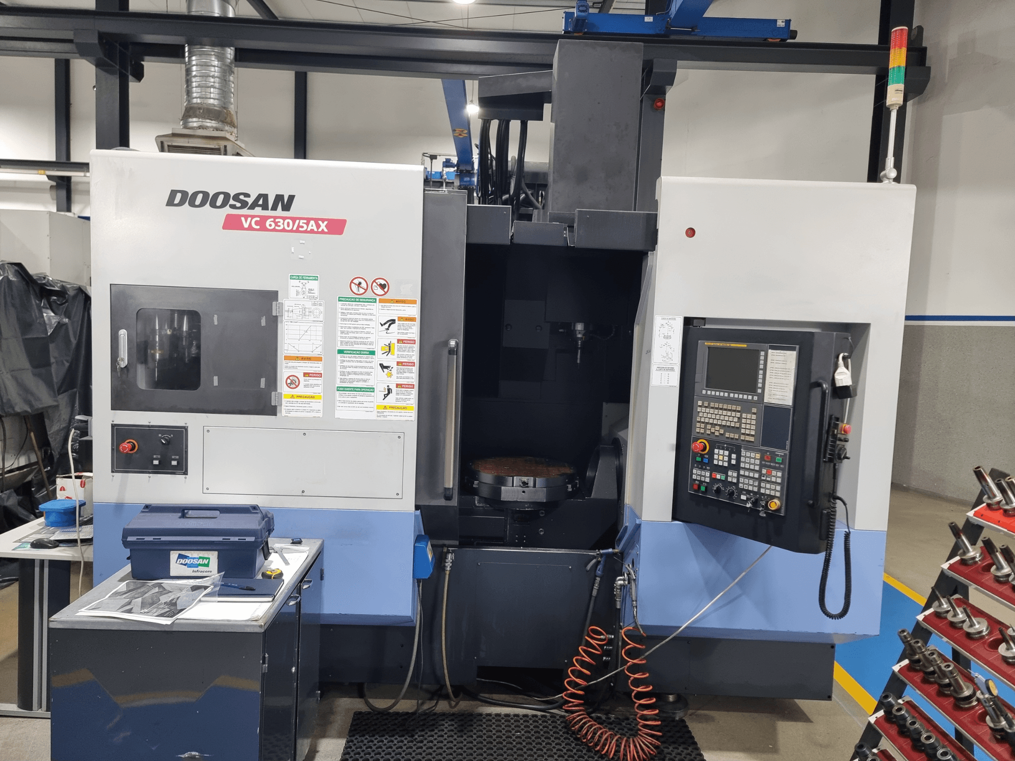 Centro de mecanizado universal DOOSAN VC 630/5AX, vista frontal en la que se aprecian el panel de control, la zona de corte y los elementos de seguridad.