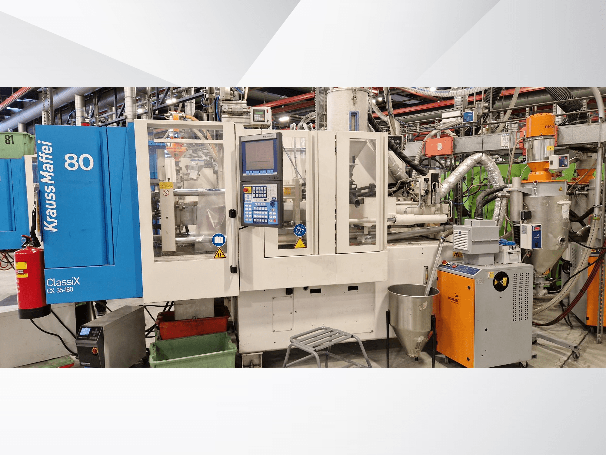 Máquina de moldeo por inyección hidráulica Krauss Maffei ClassiX CX 35-180, vista frontal, con panel de control y equipos auxiliares visibles.