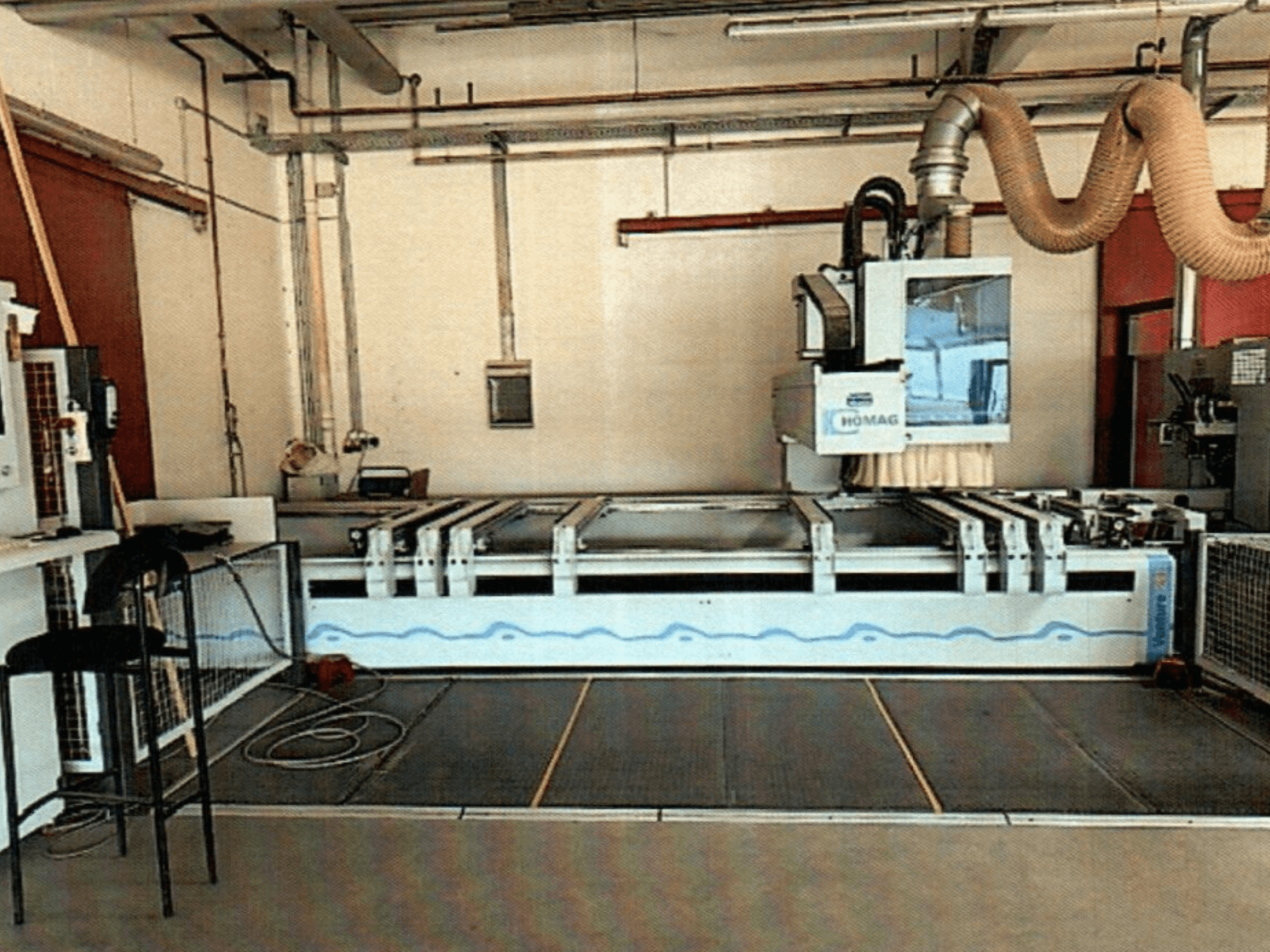 Centro de mecanizado de madera HOMAG BAZ 211/40K CNC en un taller, mostrando el panel de control de la máquina y la zona de corte.