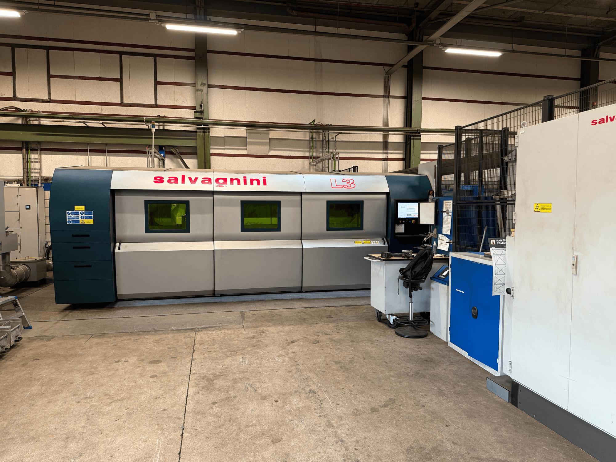 Máquina de corte por láser de fibra Salvagnini L3-4020 en su configuración de fábrica, vista frontal, en la que se aprecian el panel de control y el sistema de manipulación.