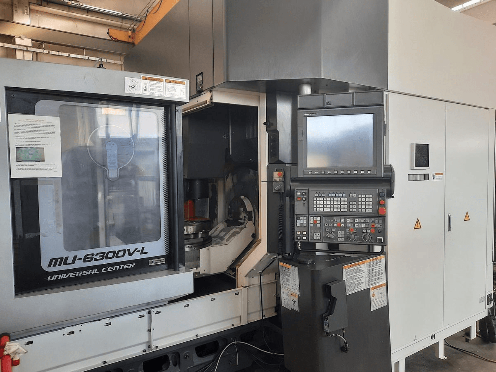 Máquina MU-6300V-L Universal Center mostrada de frente, con el panel de control, la pantalla y las instrucciones de funcionamiento visibles.