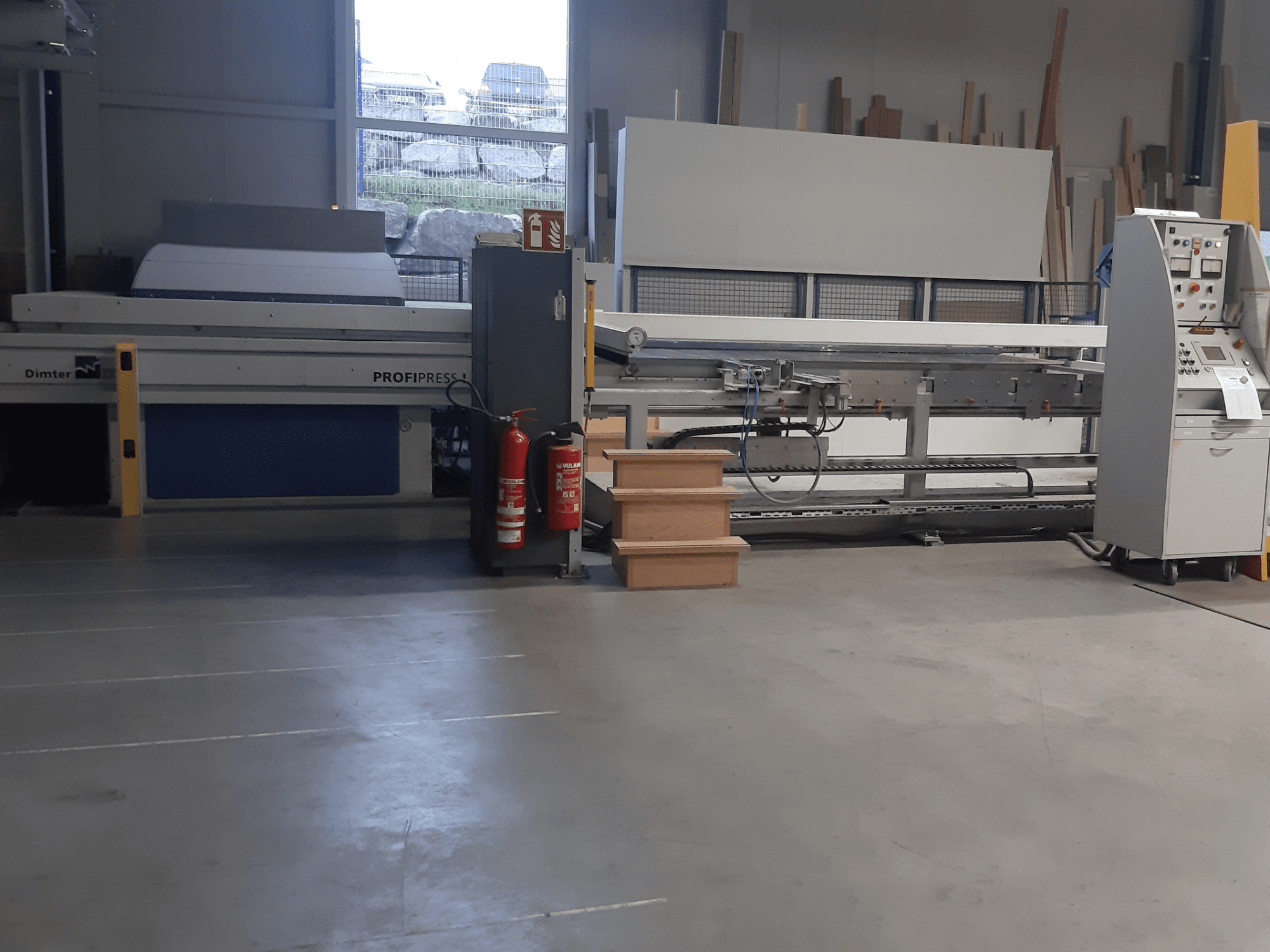 Máquina Dimter ProfiPress en un taller, vista de frente, con el panel de control y los extintores cerca.