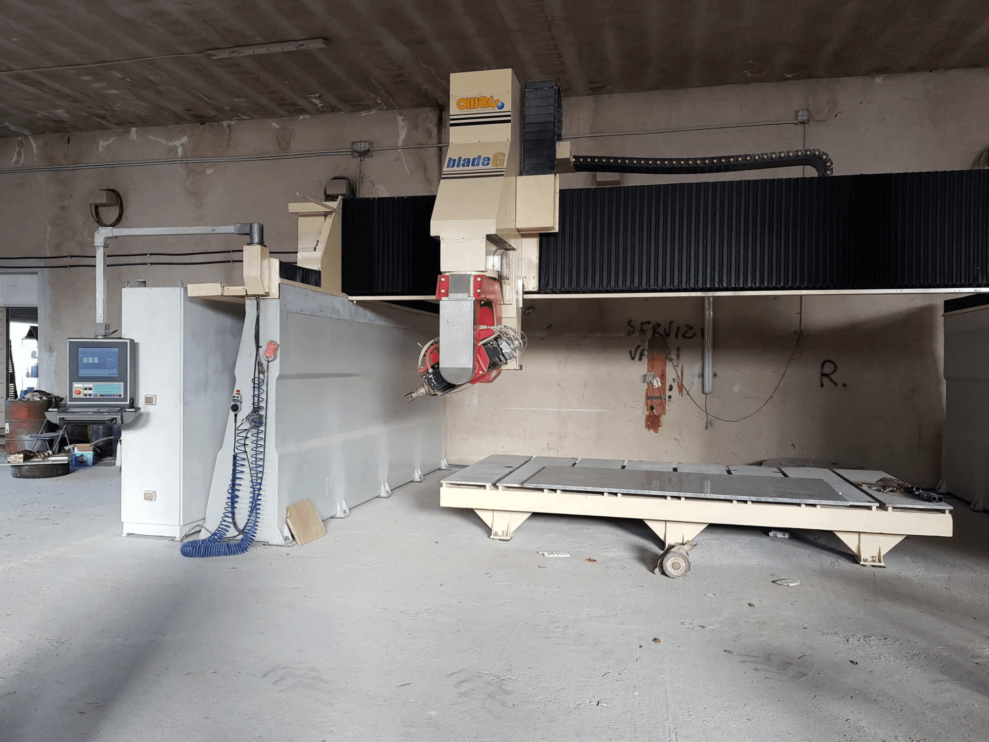 Fresadora de pórtico OMAG Blade G en un taller, vista frontal con panel de control y gran bancada de fresado visibles.