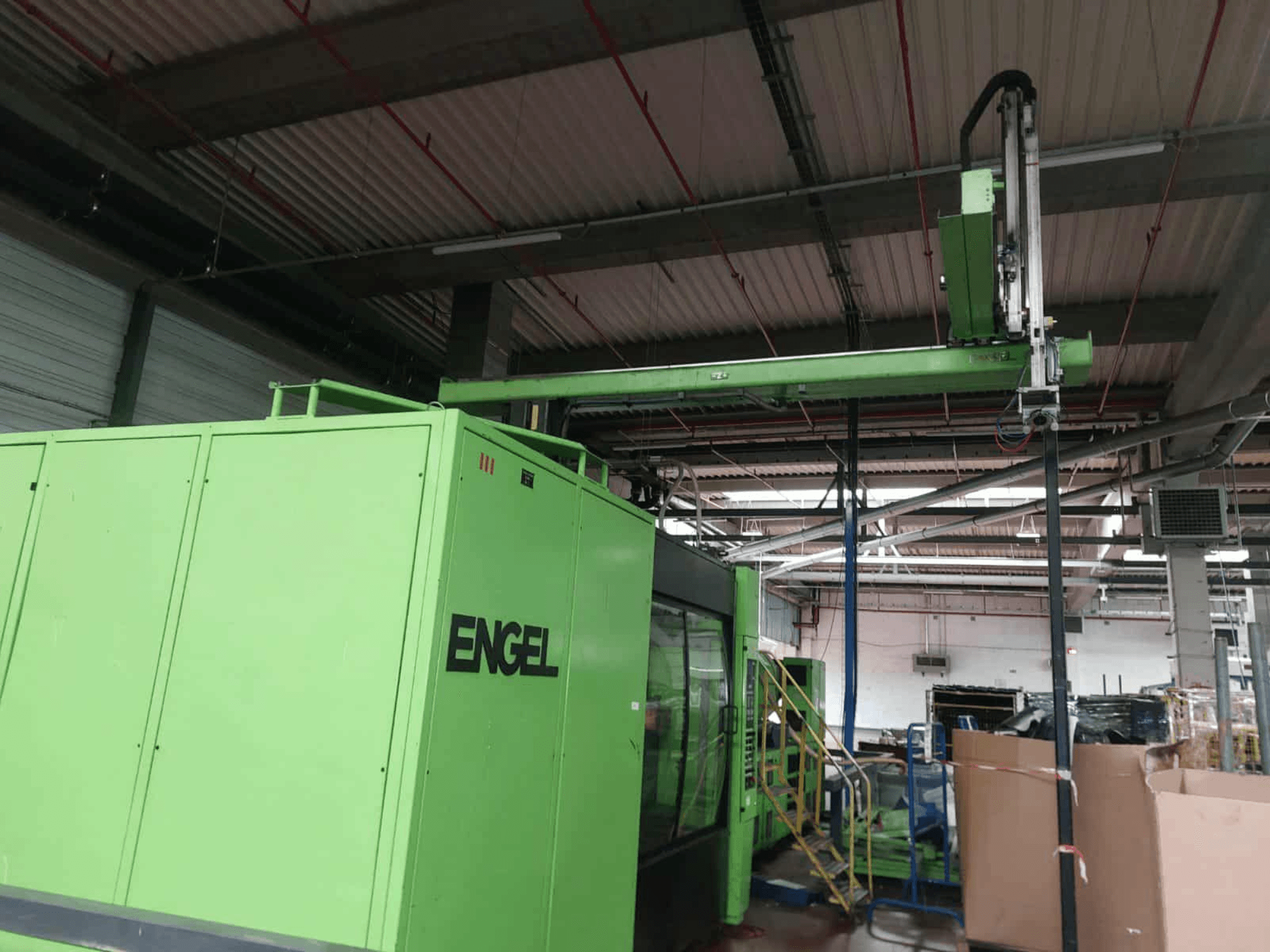 Máquina de moldeo por inyección hidráulica Engel ES 16050/1100 DUO verde, vista lateral, mostrando la zona de carga y el panel de control.
