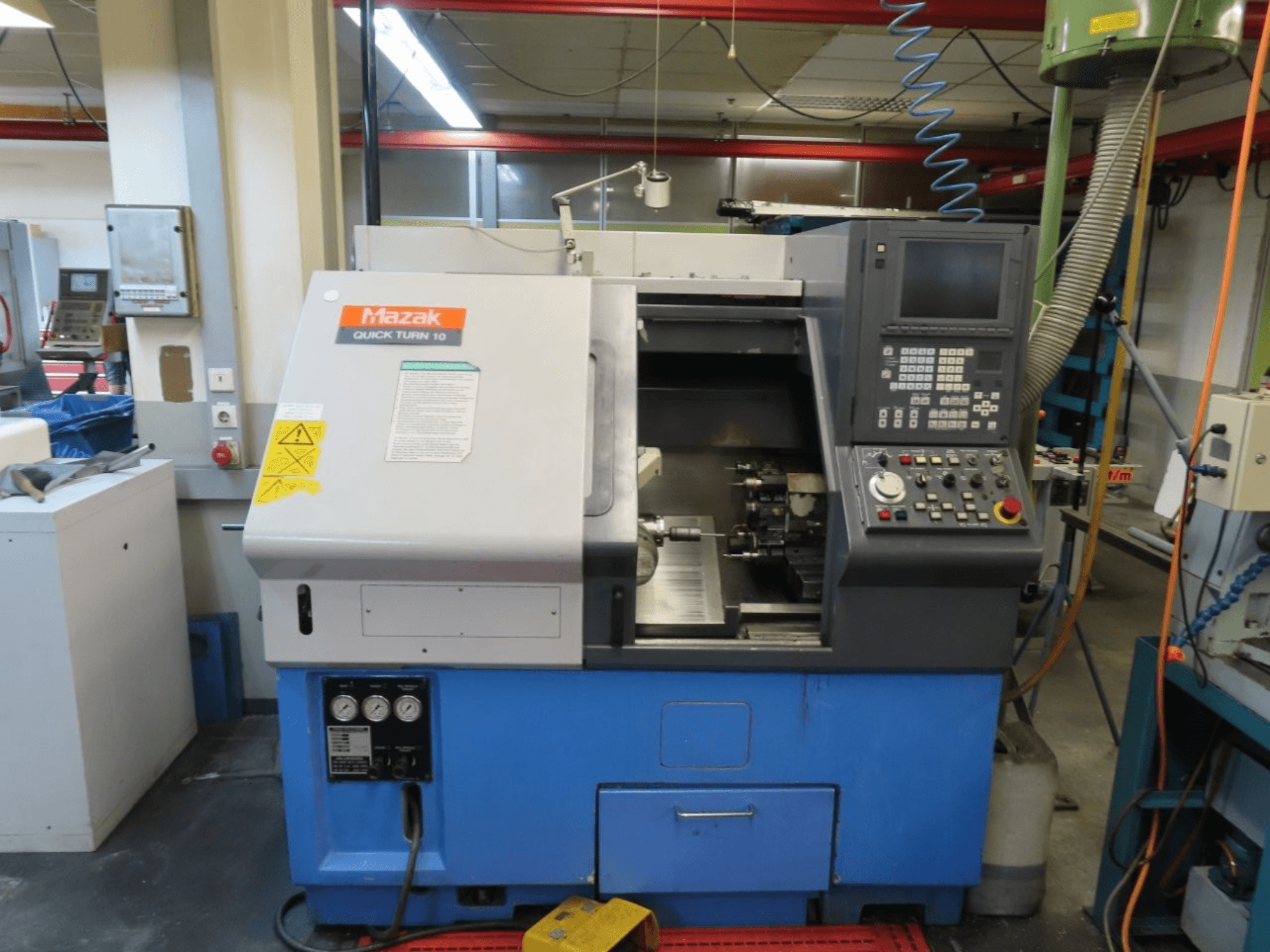 Torno horizontal Mazak Quick Turn 10 visto de frente, en el que se aprecian el panel de control, el husillo y el sistema de refrigeración.