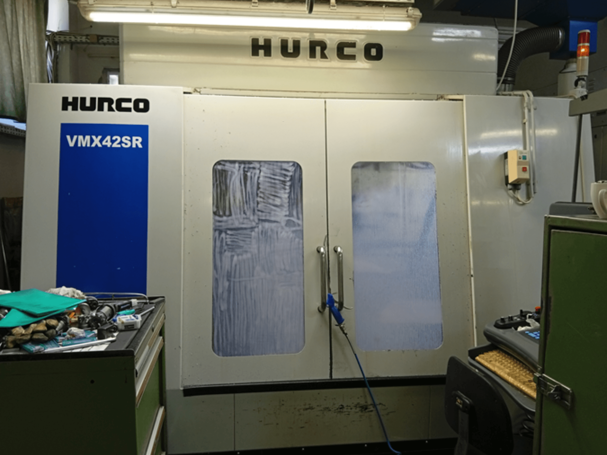 Centro de mecanizado vertical Hurco VMX 42SR en vista frontal, con panel azul, interfaz de control y espacio de trabajo limpio.
