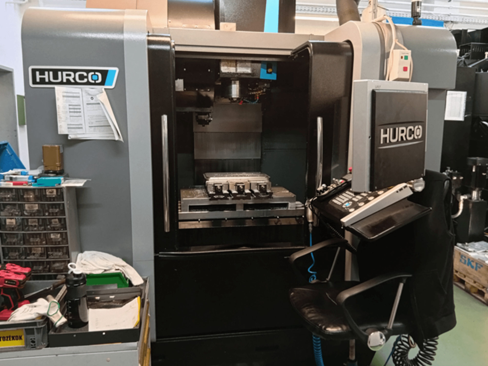 Centro de mecanizado vertical Hurco VMX 30i en vista frontal, con panel de control, mesa de trabajo y configuración operativa.