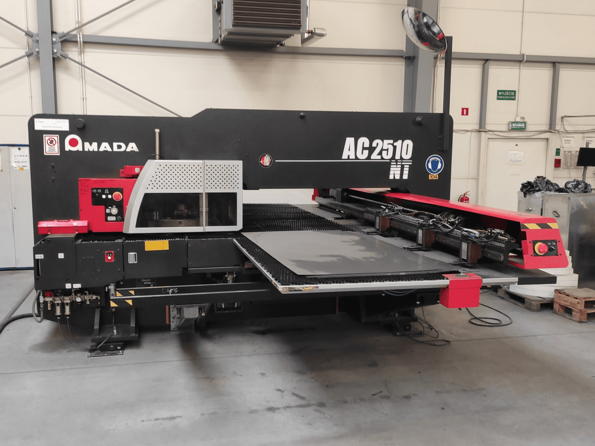 Punzonadora CNC Amada AC2510 NT, vista frontal, con panel de control y zona de carga de chapas.